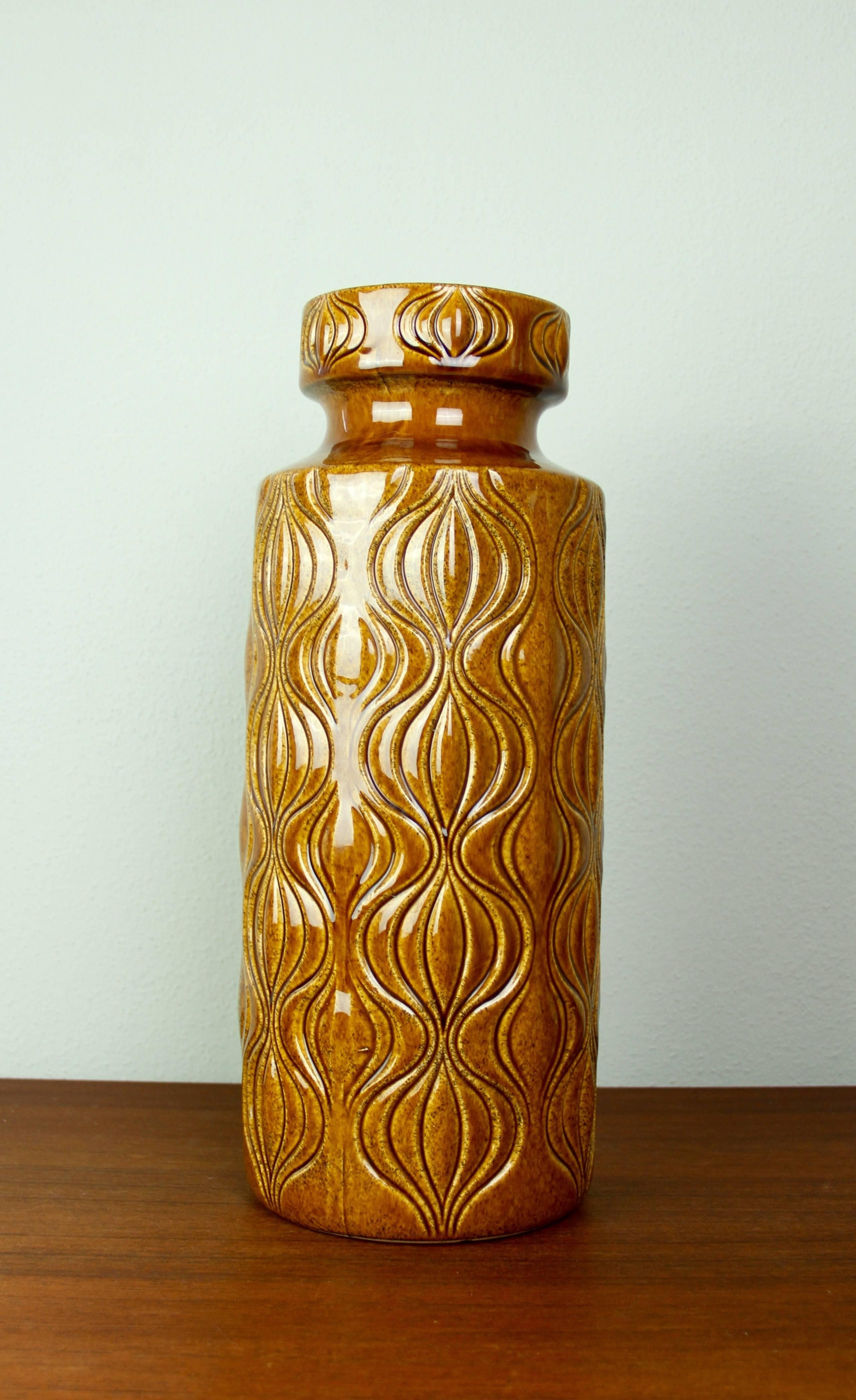 This tall collectable Mid-Century vintage floor vase was produced circa 1965 by the renowned producer of West German pottery - Scheurich Keramik. The vase features the famous 'Amsterdam' relief pattern in a lovely amber brown high gloss glaze. The