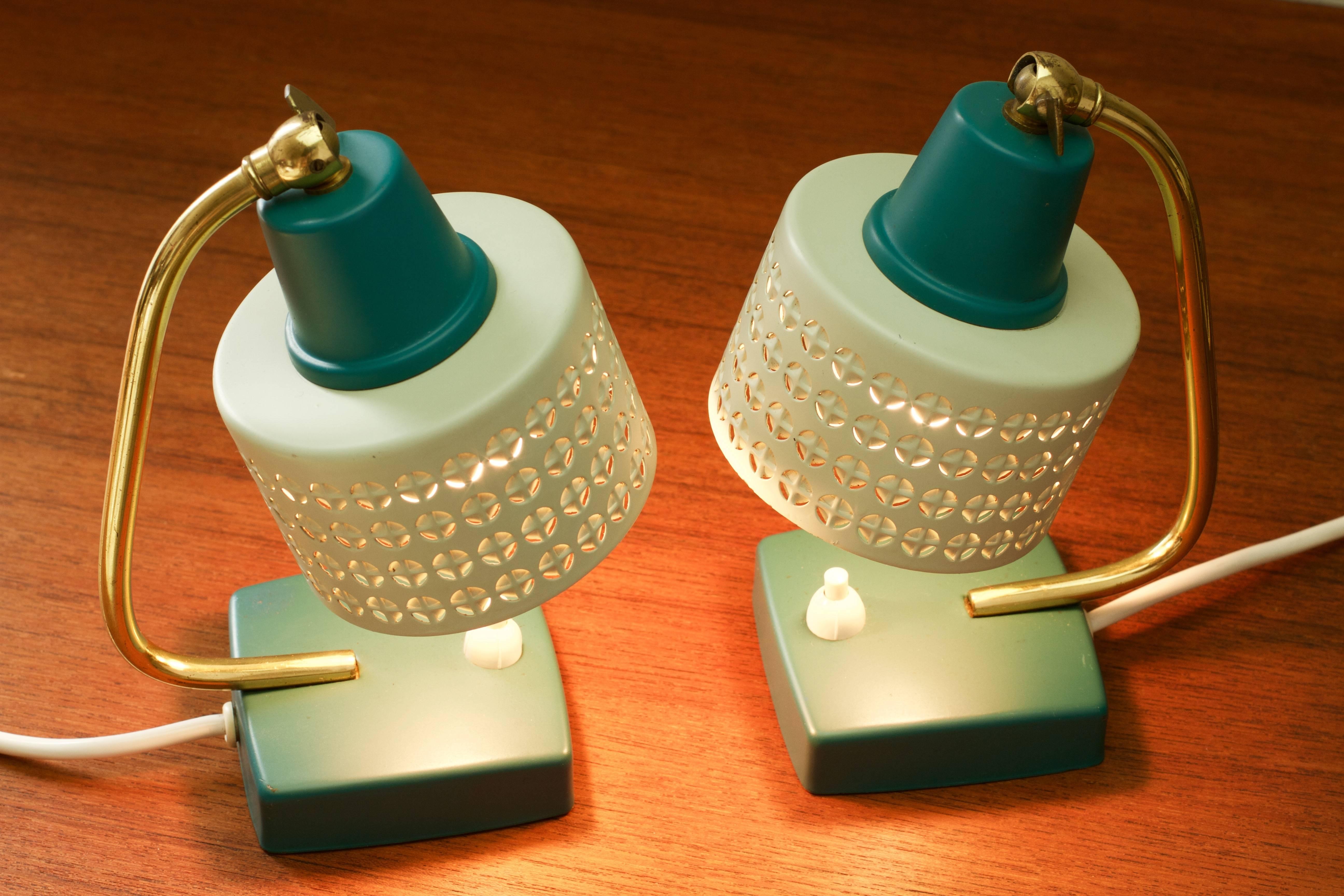 Absolutely beautiful vintage Mid-Century pair of bedside table lamps, circa 1950s. We love the adjustable perforated metal shades, which illuminate beautifully, and the teal green and off-white colors / colours along with the polished brass