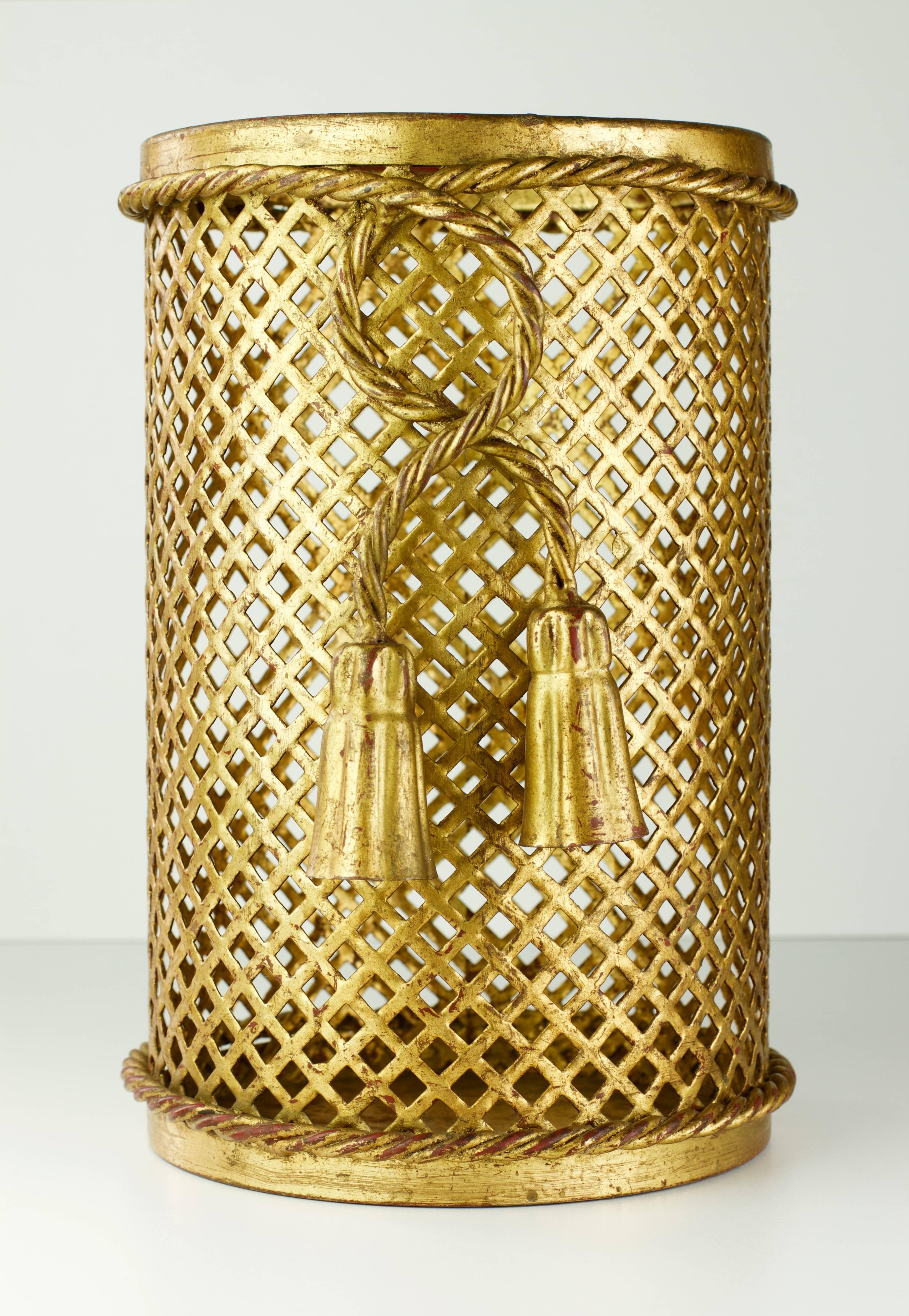 Stunning gold / gilt / gilded Hollywood Regency style trash can / bin / wastebasket made in Florence, Italy circa 1950 by Li Puma Firenze. The perforated lattice patterned metalwork with bent rope and tassel details finishes the piece perfectly.