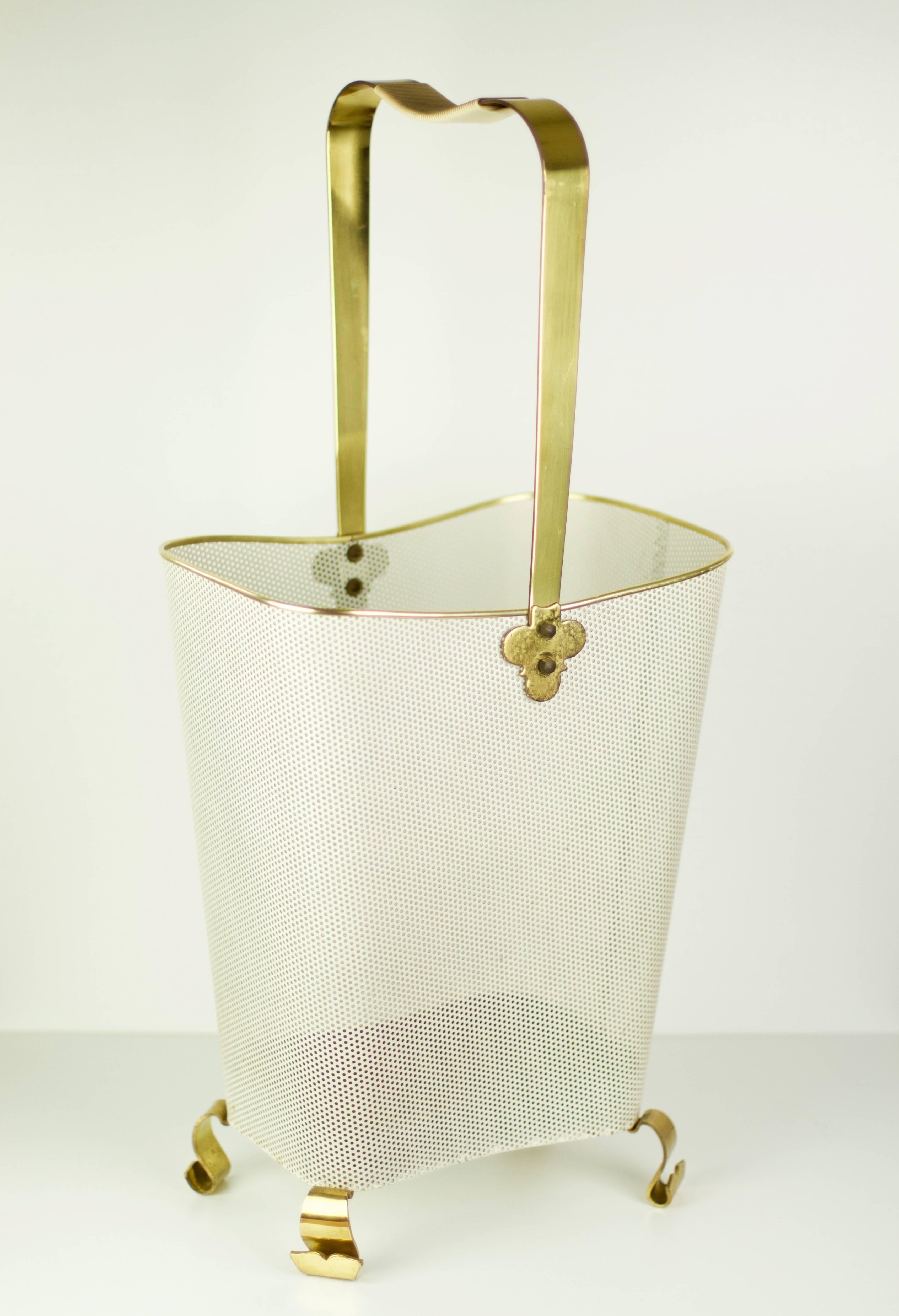 Mathieu Matégot style Mid-Century umbrella stand.

The white perforated metal basket is a classic style of Mategot and the beautifully crafted curved brass feet and delicate handle finals give the piece a unique and luxurious feel and are very