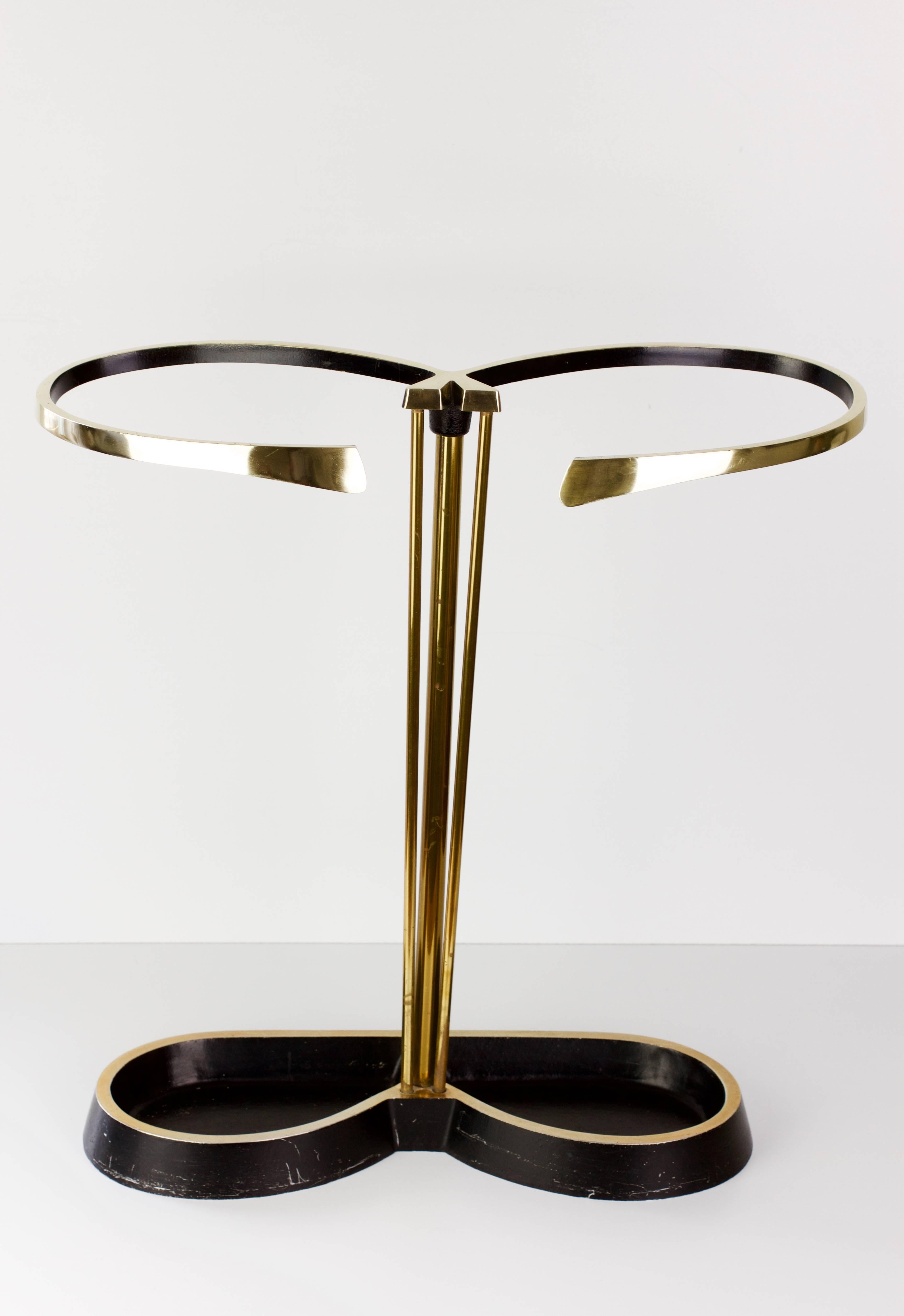 A beautiful, vintage Mid-Century Modern black and gold umbrella stand attributed to Austrian Designer Carl Auböck, Vienna, circa 1950. Both whimsical and Modernist, the stand features a heavy cast iron base with polished solid brass rods and holder