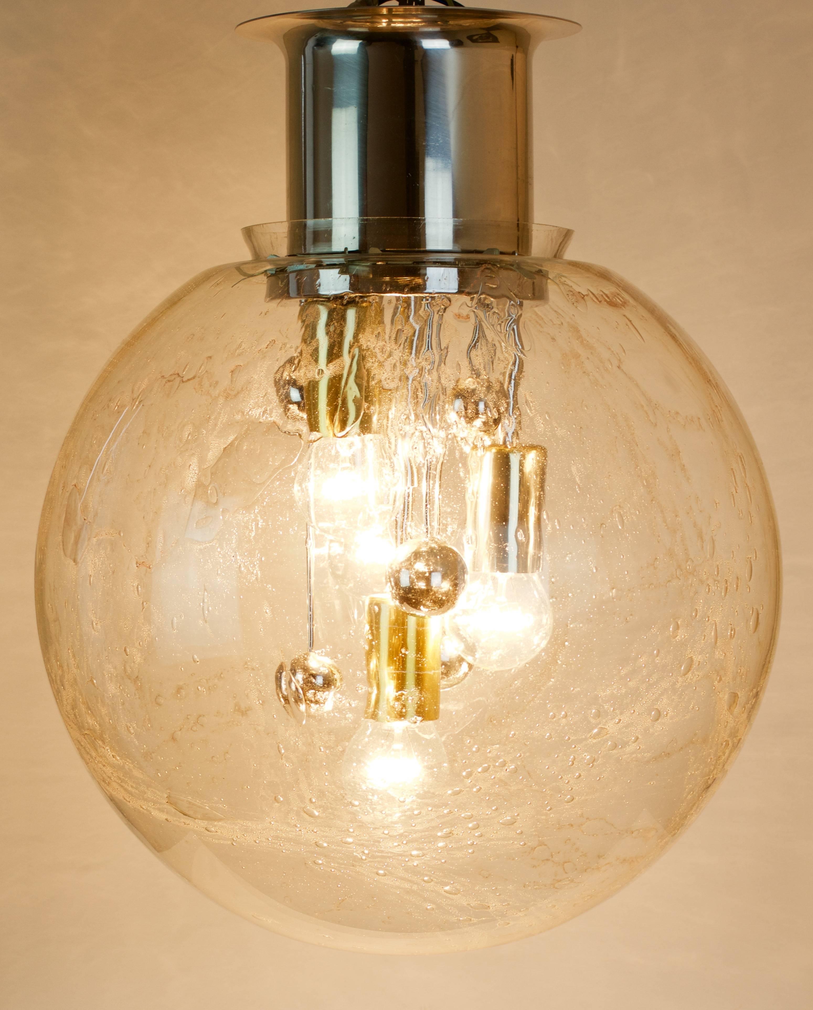 One of Three large vintage / retro / mid century modern flush mount / Chandelier Pendant light fixtures by Doria Leuchten, Germany, circa 1965-1975. The huge mouth-blown Murano glass globe features pockets of air bubbles which refract the light