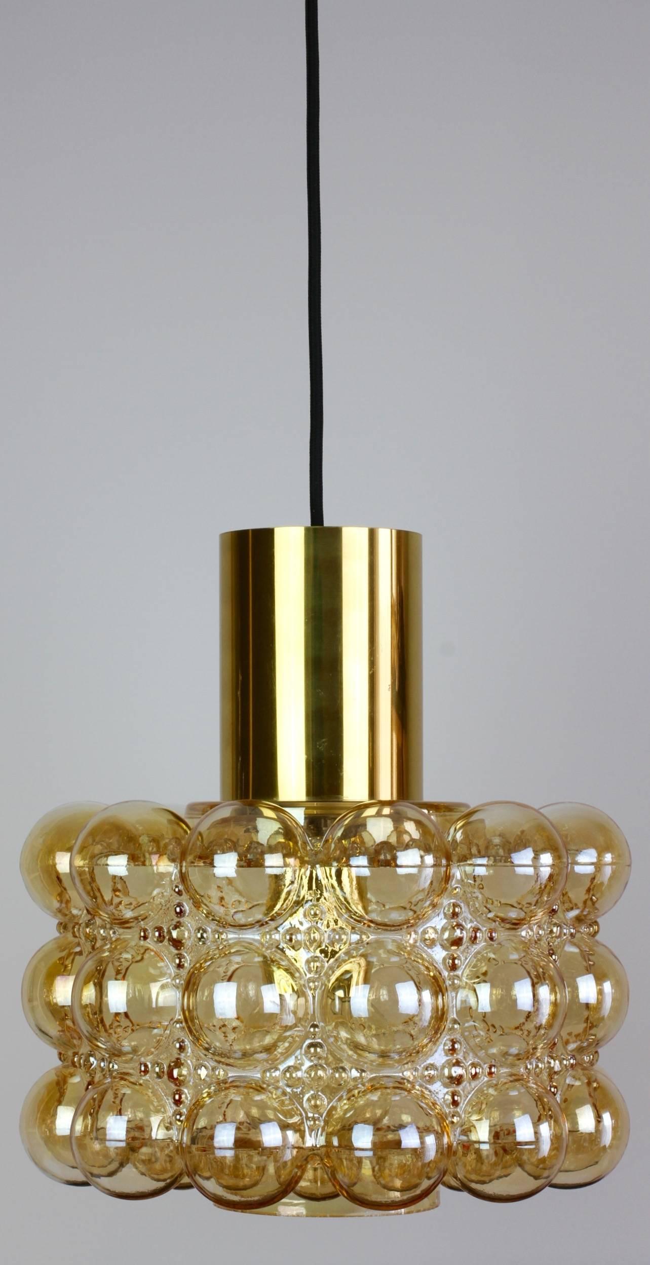 Late 1960s extra large bubble glass ceiling pendant light designed by Helena Tynell for Glashütte Limburg. The light features a beautiful lampshade made from amber or champagne colored / coloured glass with a polished brass cylinder on top.