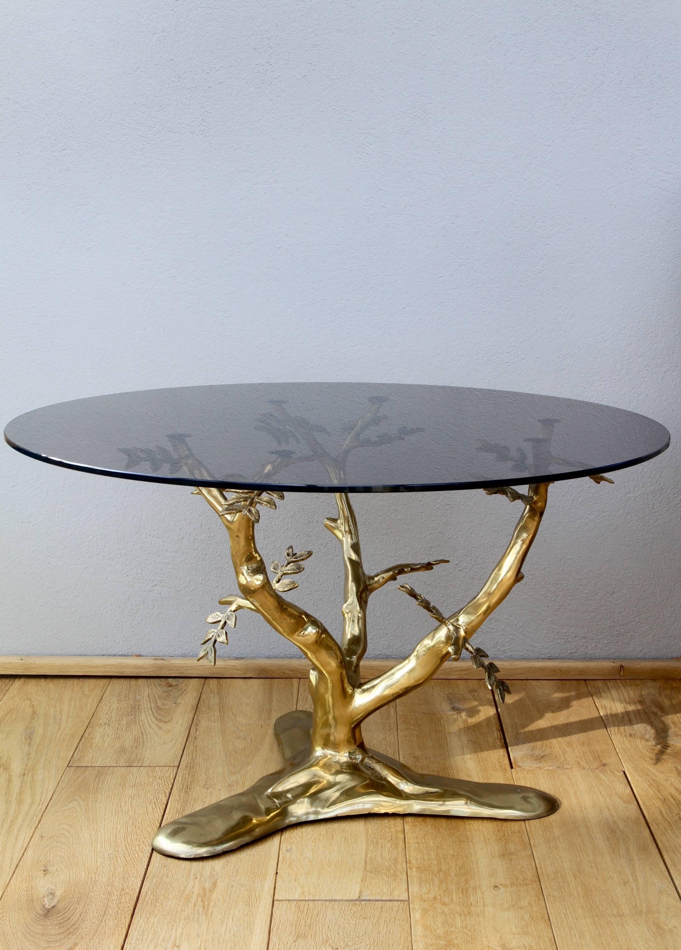 A beautifully designed and handcrafted table in the manner of Willy Daro, circa 1975. Cast in brass, the branches of the 'Bonsai' tree support the round smoked glass tabletop and bring a whimsical touch of nature in to any room whether a midcentury