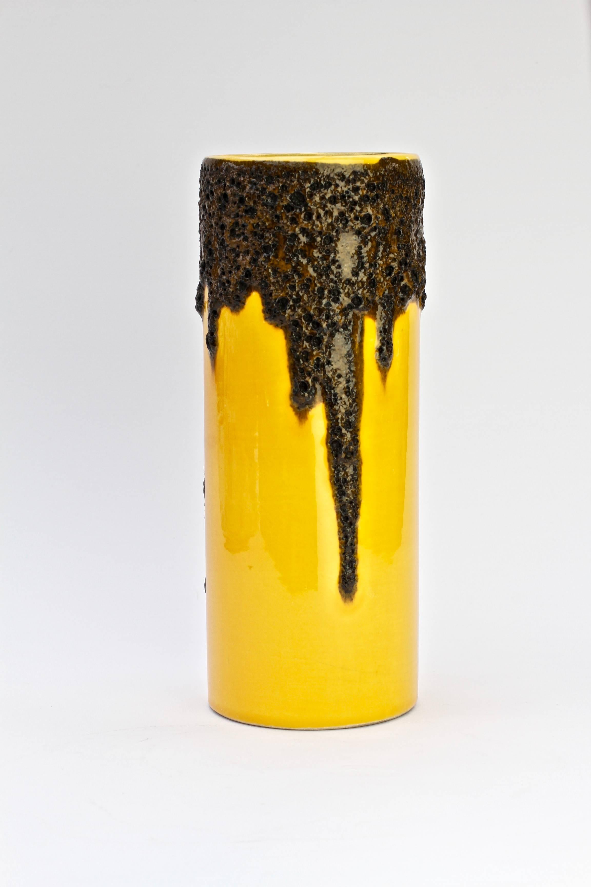 A tall, cylindrical, beautiful and bright vivid yellow vase by Fohr Pottery, circa 1970. The bright yellow looks wonderful against the textured black fat lava drip glaze. 

A wonderfully fun vintage collectible to brighten up your home