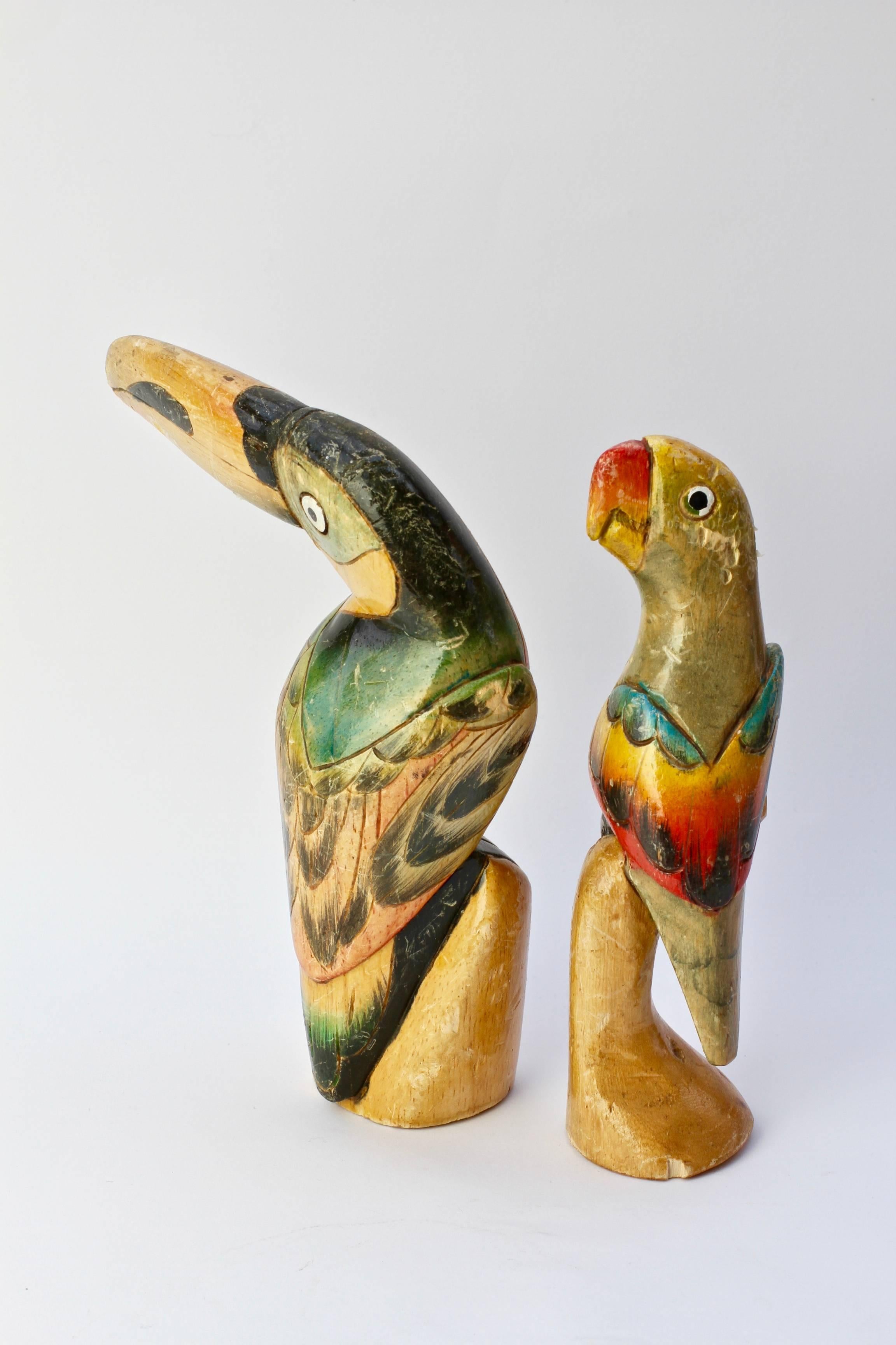 Post war pair of colorful (colorful) hand-carved and painted tropical birds. Dating from the 1940s and made for the tourist market, we expect these birds where made in South America or the West Indies. Showing a lovely patina, these birds would make