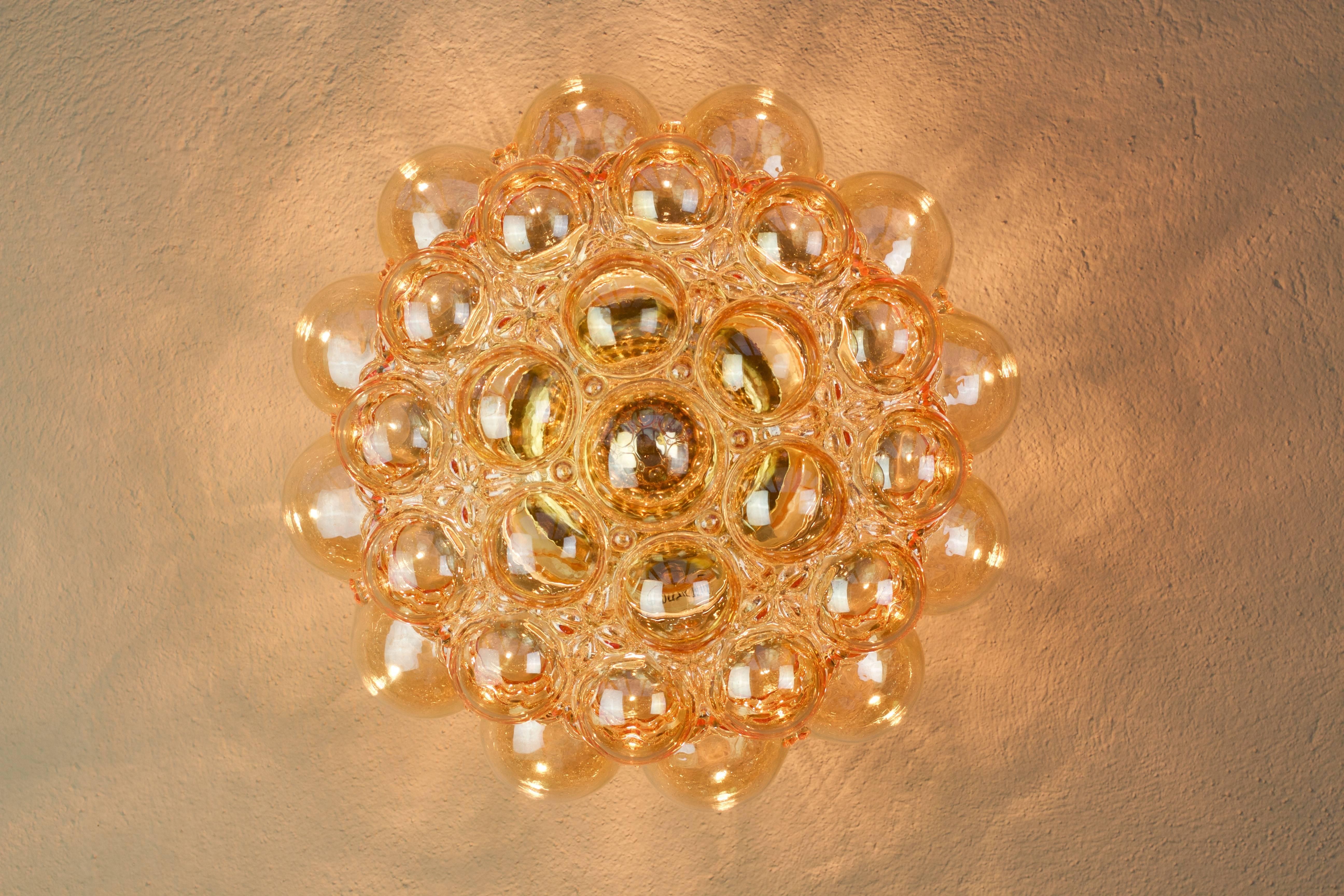 One of a set of eight large Amber / Champagne colored / coloured bubble glass sconces designed by Helena Tynell for Glashütte Limburg in the late 1960s / early 1970's. These are the largest versions produced and are complete with their polished