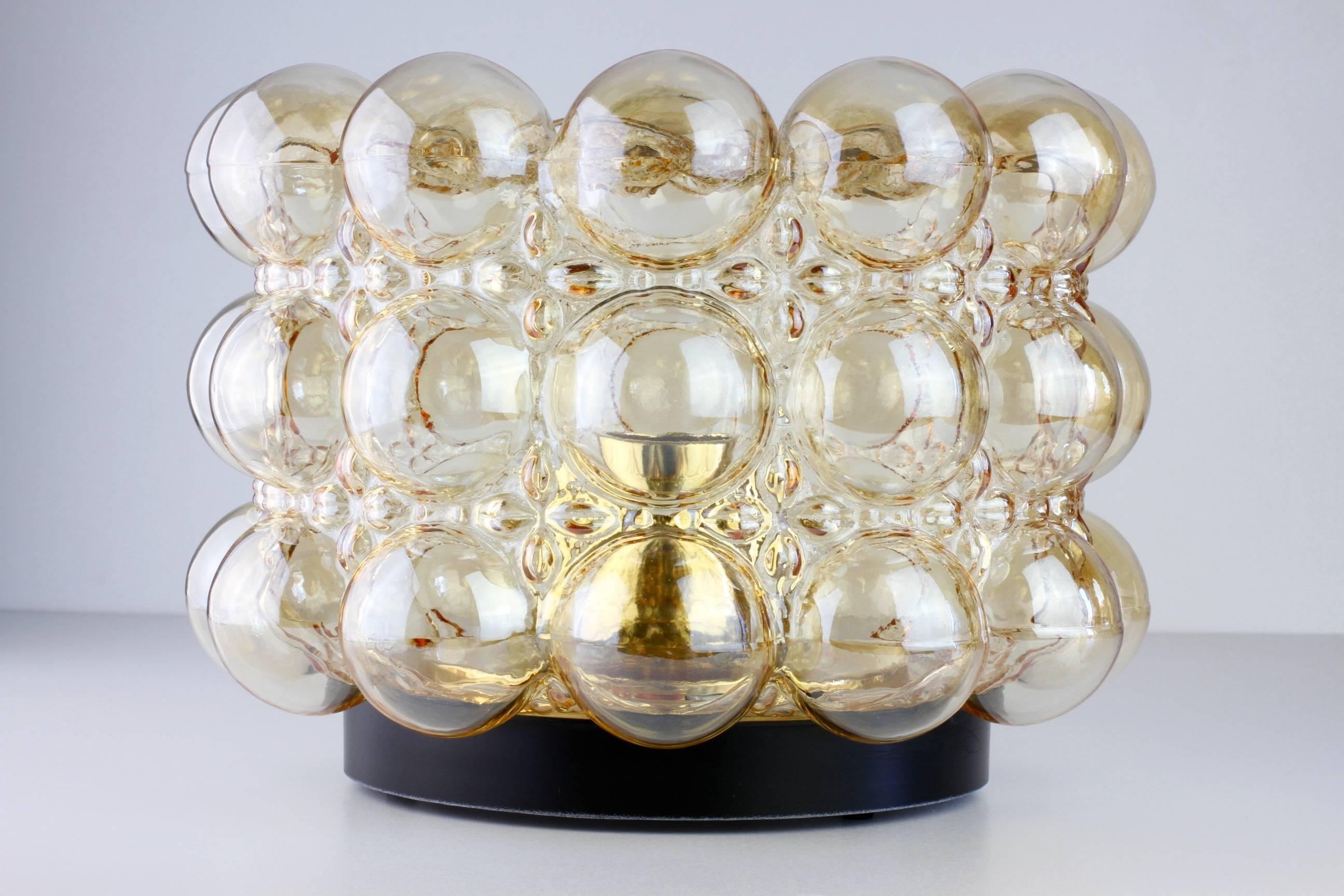 One of a beautiful pair of amber or champagne colored (colored) bubble glass sconces designed by Helena Tynell for Glashütte Limburg in the late 1960s or early 1970s. They look simply stunning mounted on the ceiling or wall and give a wonderful warm