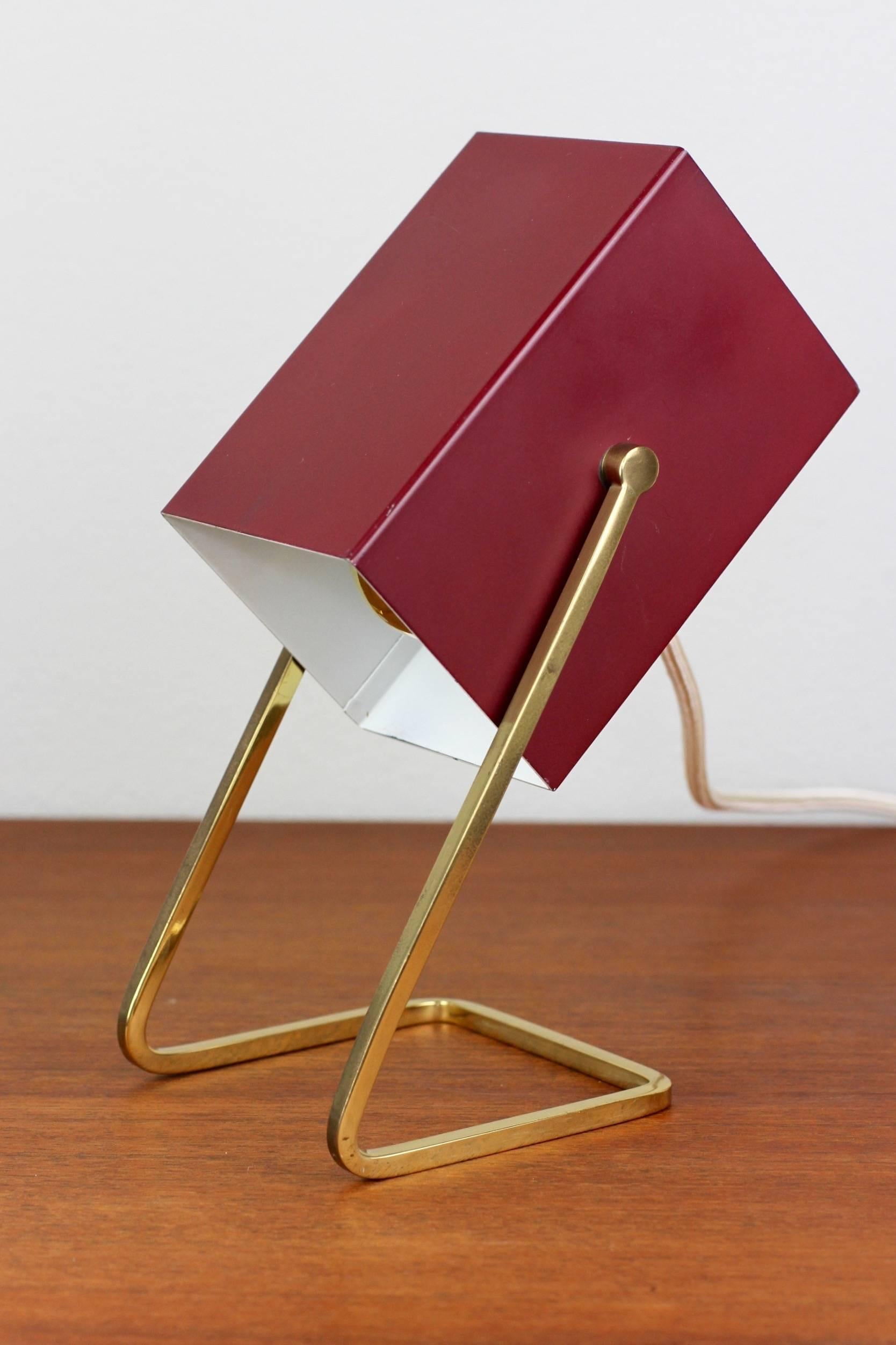 A 1950s German Minimalist cube table lamp/desk light by Kaiser Leuchten. The design speaks for itself - simple, clean and elegantly Cubist. With it's ruby red adjustable metal shade sitting on it's square brass tube base, it's an impressive and