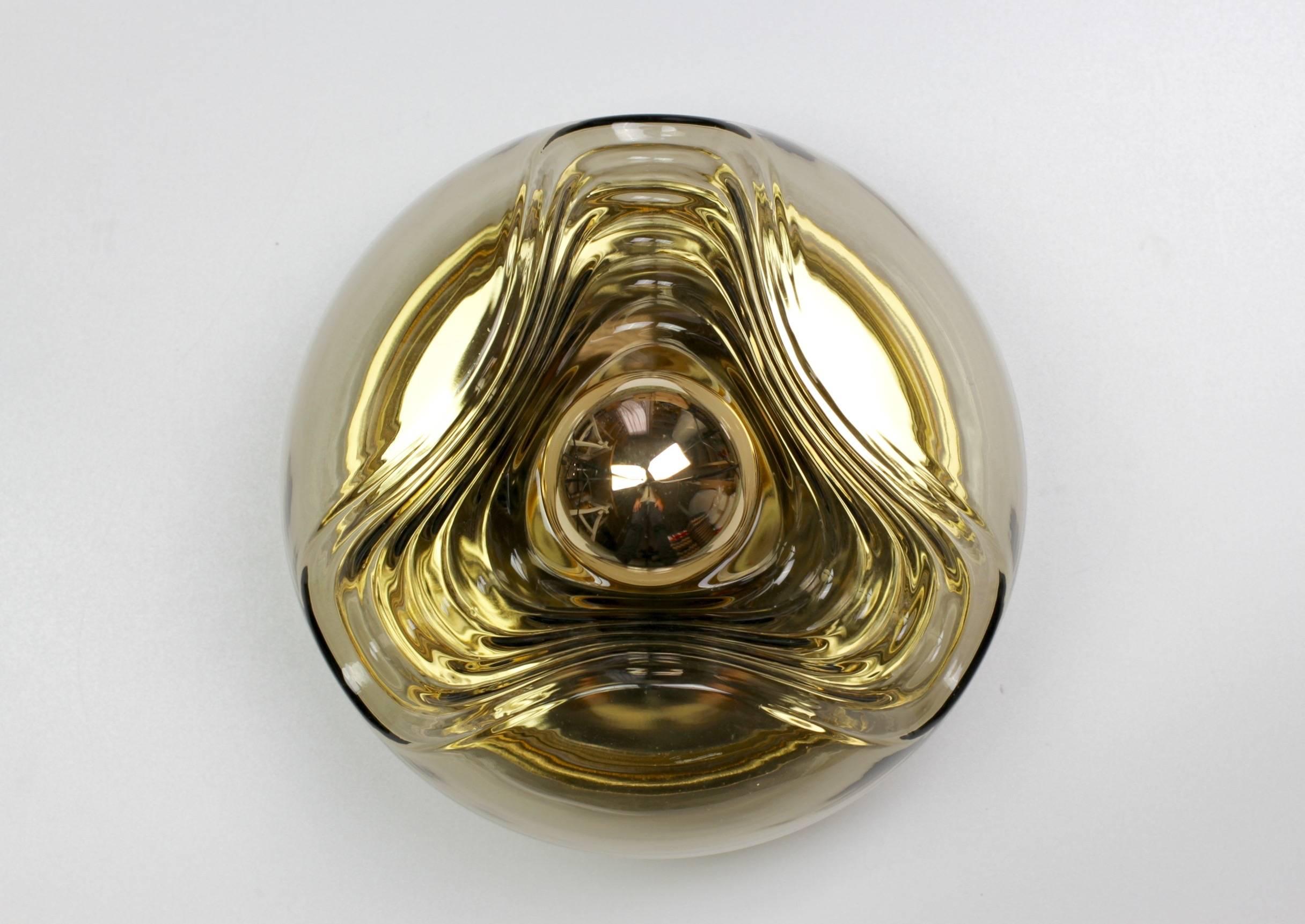 Beautiful Mid-Century flush mount wall light or sconce designed by Koch & Lowy for Peill & Putzler in the 1970s. This is an absolutely Classic piece of design, featuring a smoked colored (colored) glass globe shade with a waved/ribbed molded