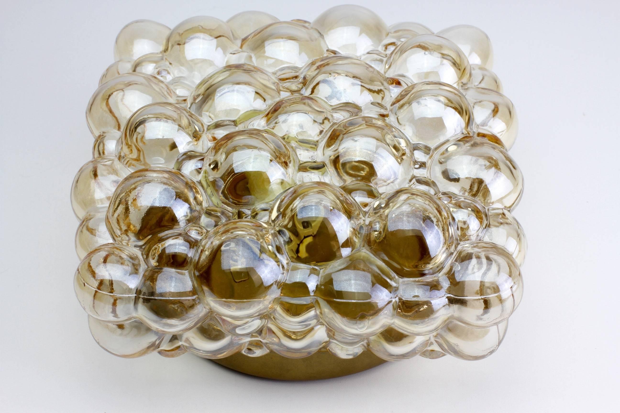 One of a pair of Mid-Century bubble glass wall or ceiling flush mount lights designed by Helena Tynell for Glashütte Limburg, Germany, circa 1960.

 The glass has a subtle amber / champagne color (colour) and sits within a gold colored (coloured)