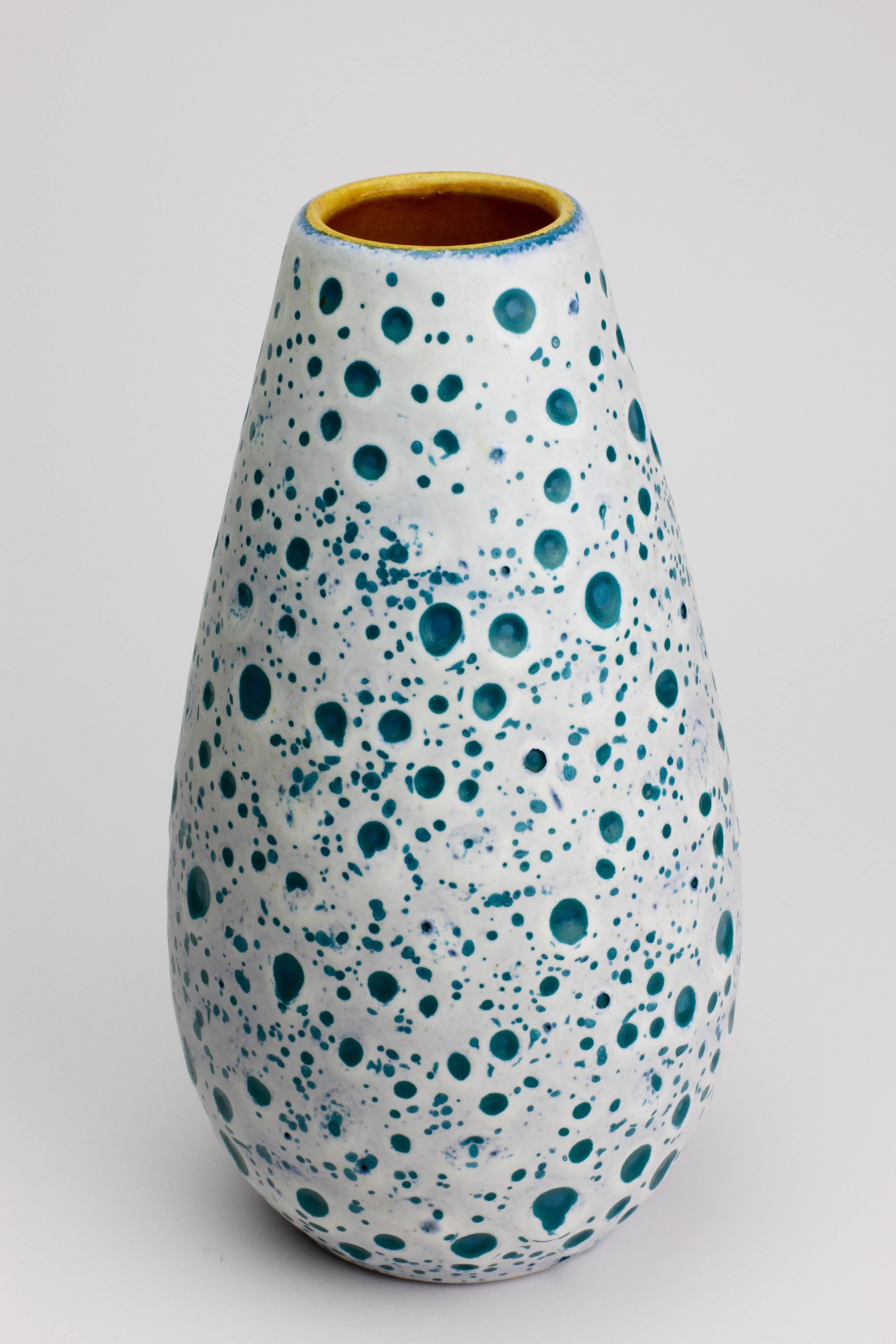 Beautiful Mid-Century example of West German pottery by Ü-Keramik, circa 1960. Featuring a stunning color combination of white over turquoise with a yellow inner glaze, the outer glaze resembles the surface of the moon with craters exposing the