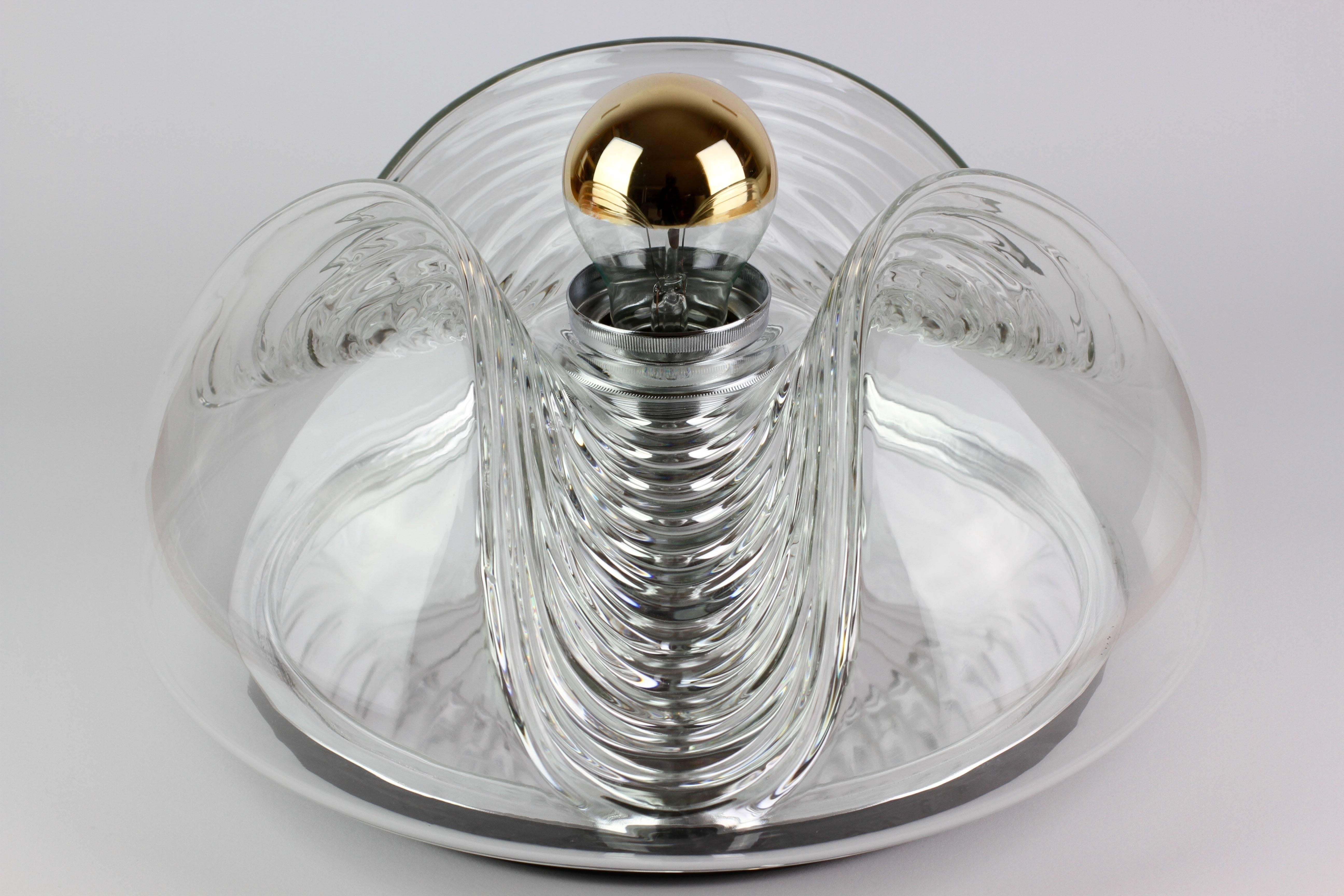 Mid-Century flush mount wall light or sconce designed by Koch & Lowy for Peill & Putzler in the 1970s. This is an absolutely classic piece of German design, featuring a clear glass globe shade with a waved/ribbed molded bubble form, casting a