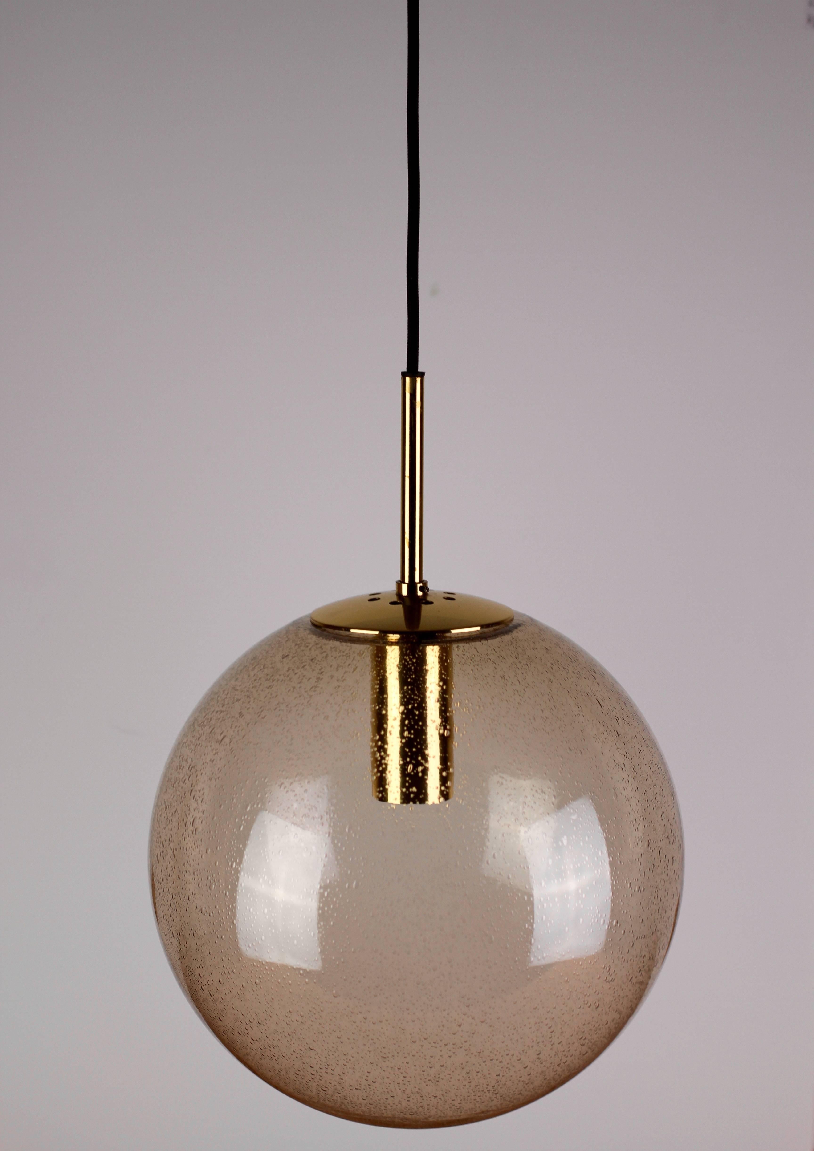A large Mid-Century hanging pendant light by Glashütte Limburg. Made in the late 1960s throughout to the late 1970s, this gorgeous light features a mouth blown smoked glass globe containing many tiny bubbles resembling water droplets. All hardeware