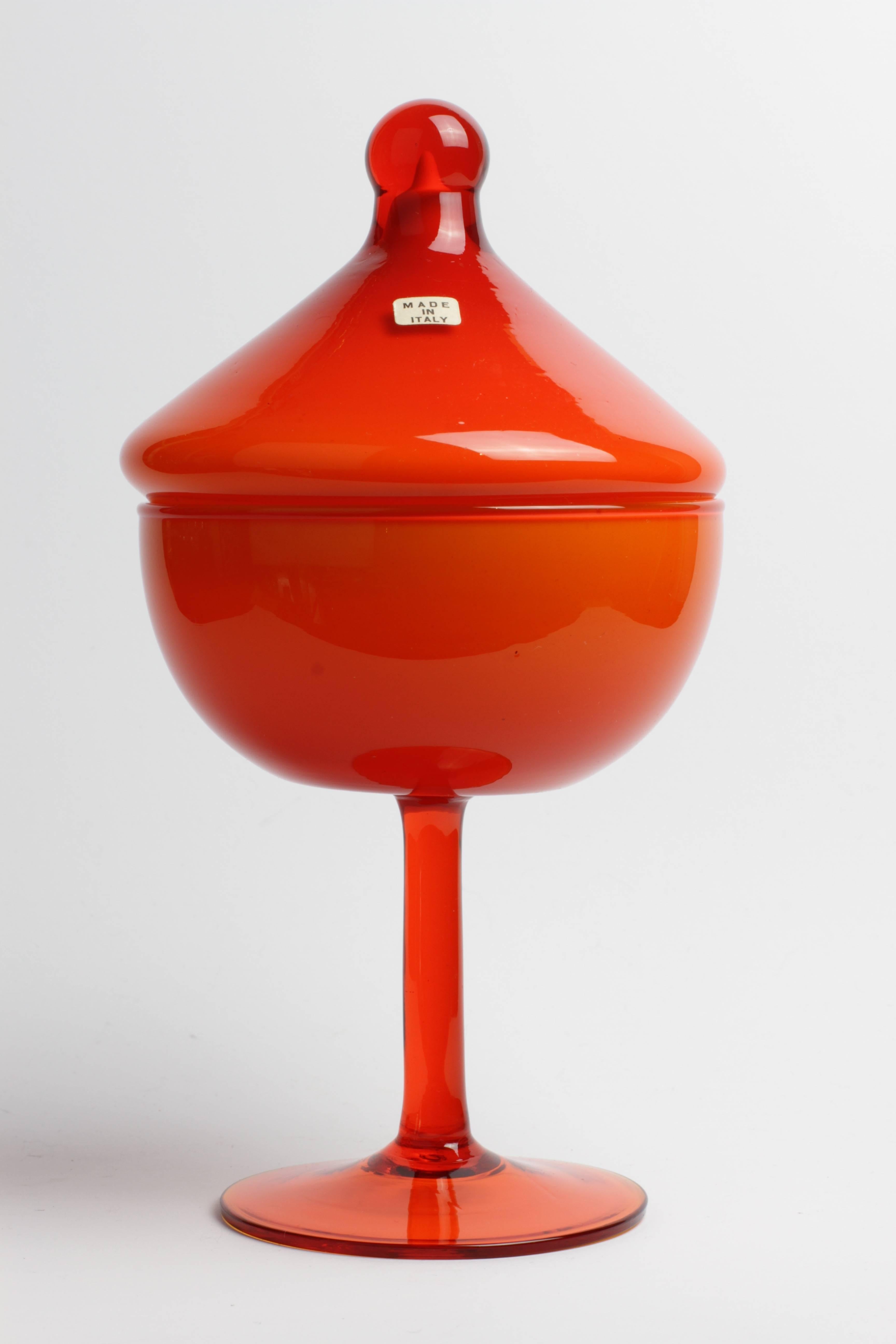 A lovely little piece of Mid-Century Italian glass, possibly made in Murano. This colorful and fun lidded jar features vibrant cear orange glass over white milk glass and would be perfect for keeping sweets or biscottis hidden away for those rainy