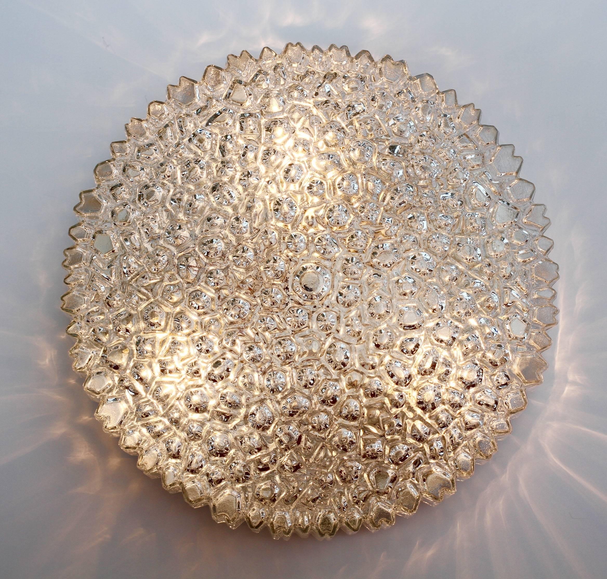 A beautiful and large flush mount light fixture by Glashütte Limburg, circa 1970s. Featuring a wonderful mouth blown, molded and textured clear glass shade resembling ice crystals, this Mid-Century vintage lamp illuminates beautifully, casting a