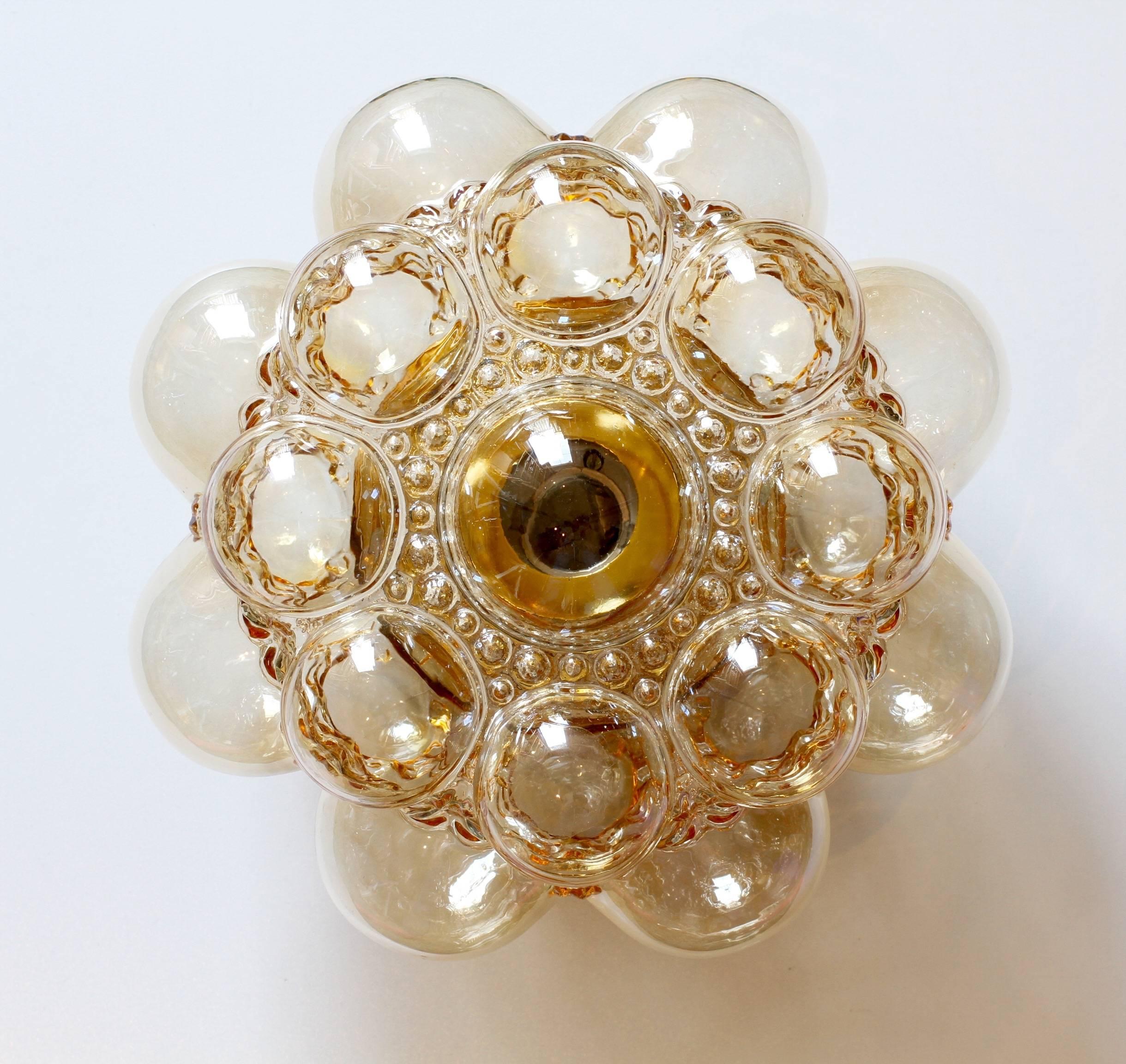 One of a set of four beautiful Amber / Champagne colored / colored bubble glass sconces designed by Helena Tynell for Glashütte Limburg in the late 1960s-early 1970s. These are the smallest versions produced and are complete with their polished