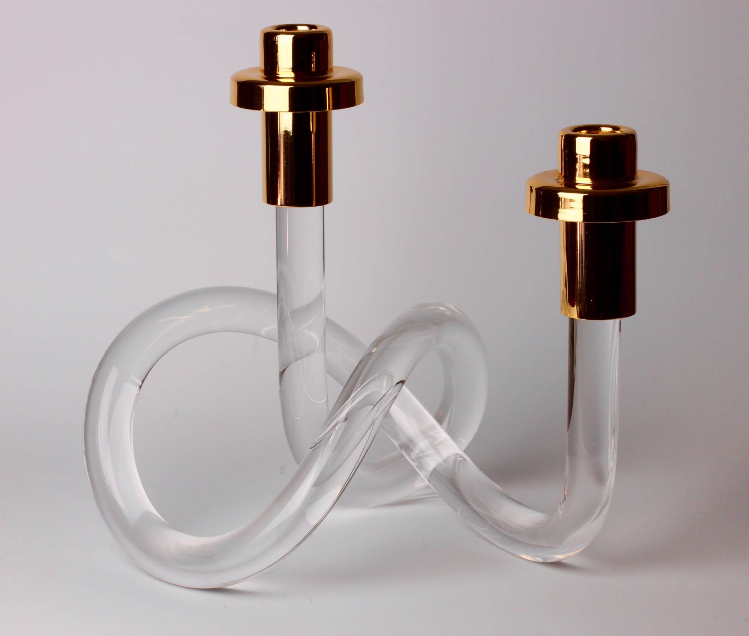 A Lucite and gold-plated brass double candlestick holder/candelabra by American designer Dorothy Thorpe, circa 1940s. With it's use of a single piece bent and twisted acrylic to form the whimsical base, it is often referred to as the 'pretzel'
