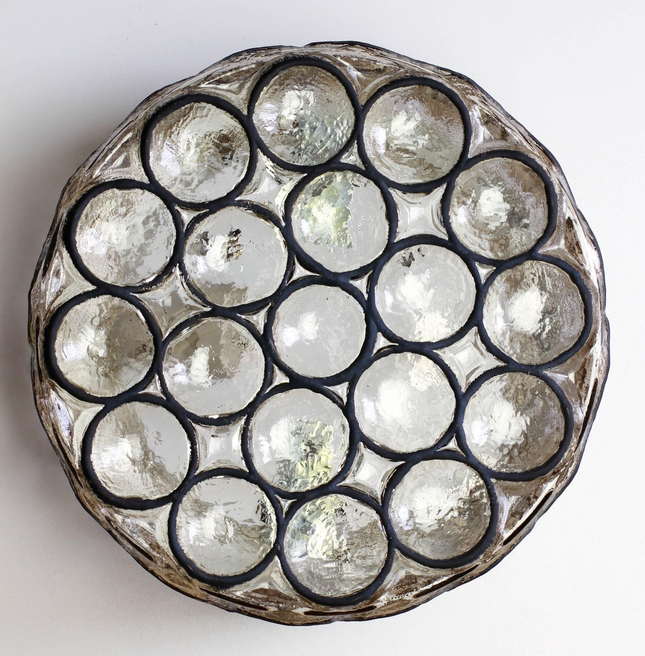 One of a set of three vintage Mid-Century, circular iron and glass flush mount light / sconce by Glashütte Limburg, Germany circa 1965. Featuring thick heavy blown glass with concaved round 