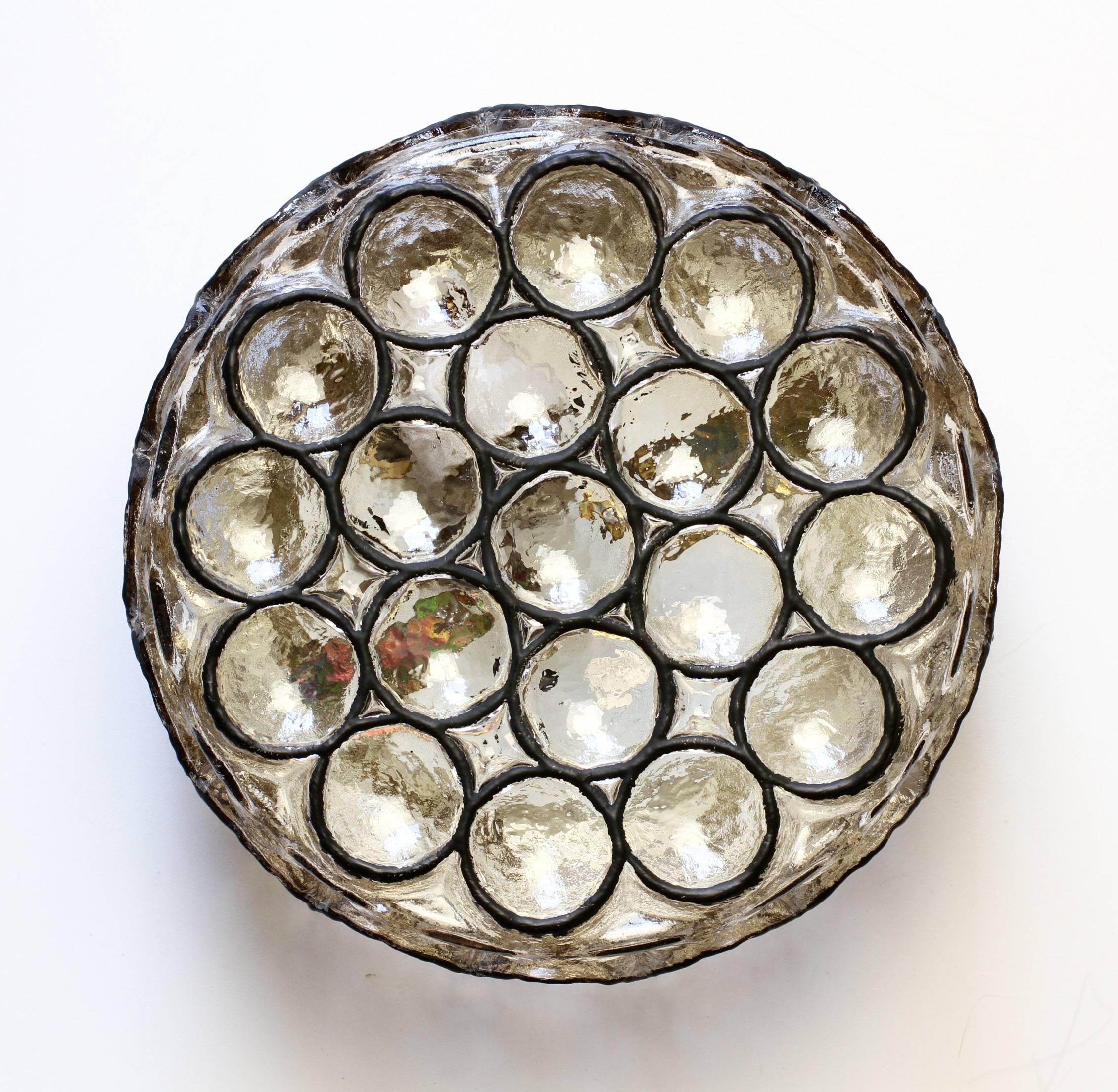 One of a beautiful pair of circular iron and glass flush mount lights / sconces by Glashütte Limburg, Germany circa 1965. Featuring thick heavy blown glass with concaved round "Iron" rings which cast a wonderful light across a wall or