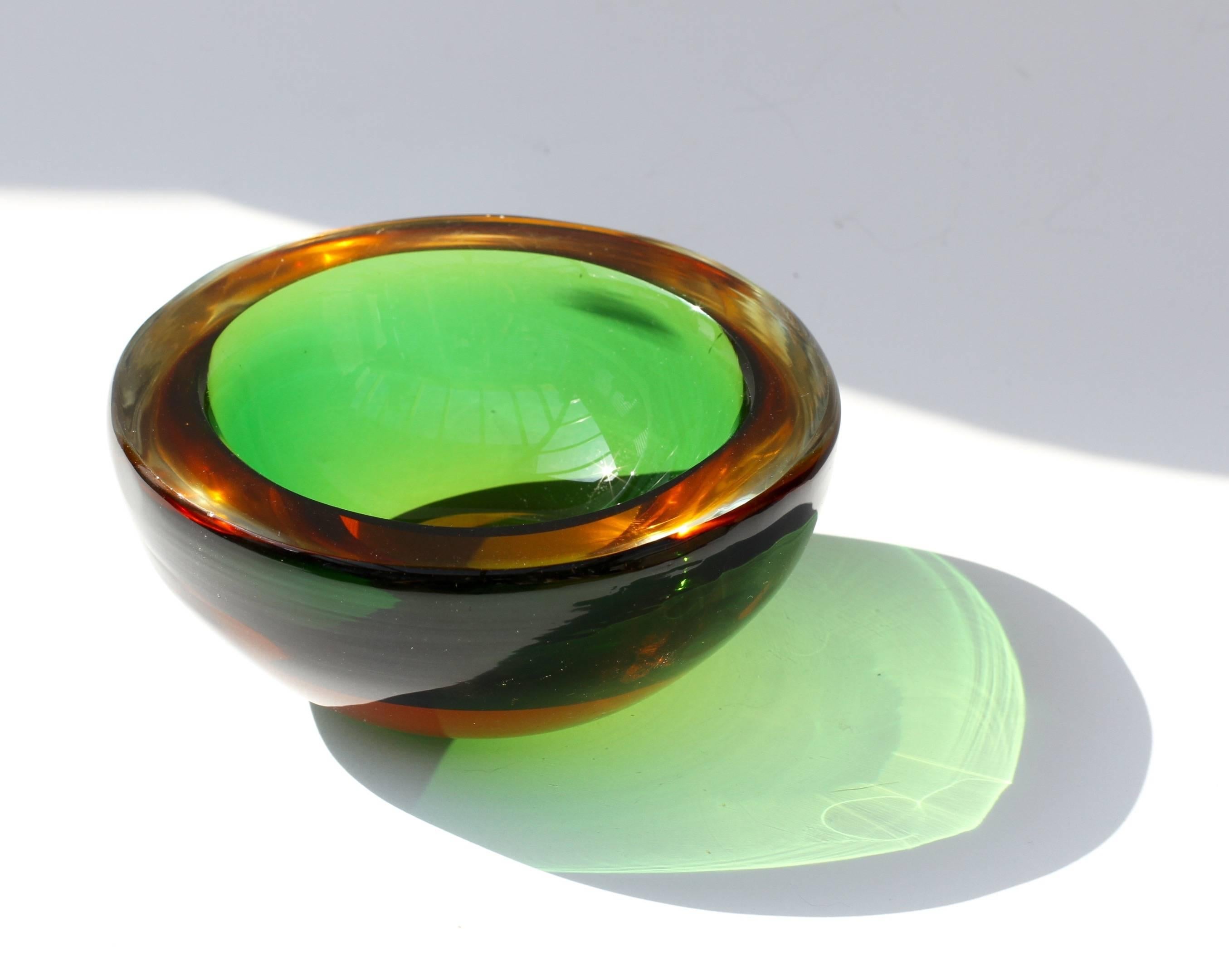 A beautiful Italian, midcentury bowl attributed to Murano glass designer Flavio Poli, circa 1960. Featuring the 'Sommerso' technique using emerald green and wonderful, warm golden amber colored glass is both understated and elegantly simple