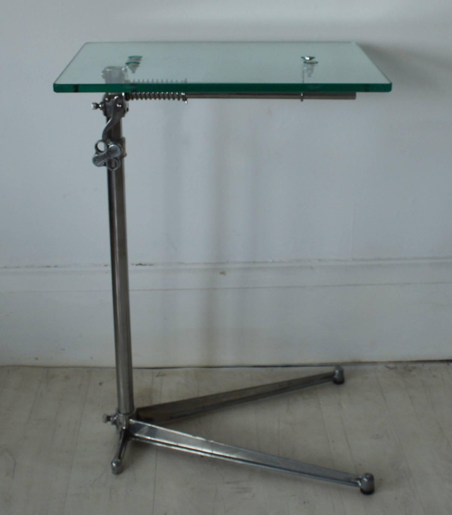 
Stylish side or work table with an elegant industrial look.

Made of polished steel and aluminium with a new toughened glass top.

The top is adjustable by loosening the handle on the side.

The top can also be tilted.

On two original