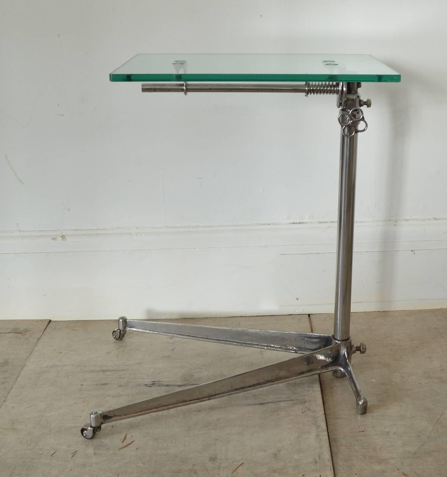 Stylish side or work table with an elegant industrial look.

Made of polished cast iron and steel with a new toughened glass top.

The top is adjustable by loosening the handle or wheel on the side.

The top can also be tilted.

On the