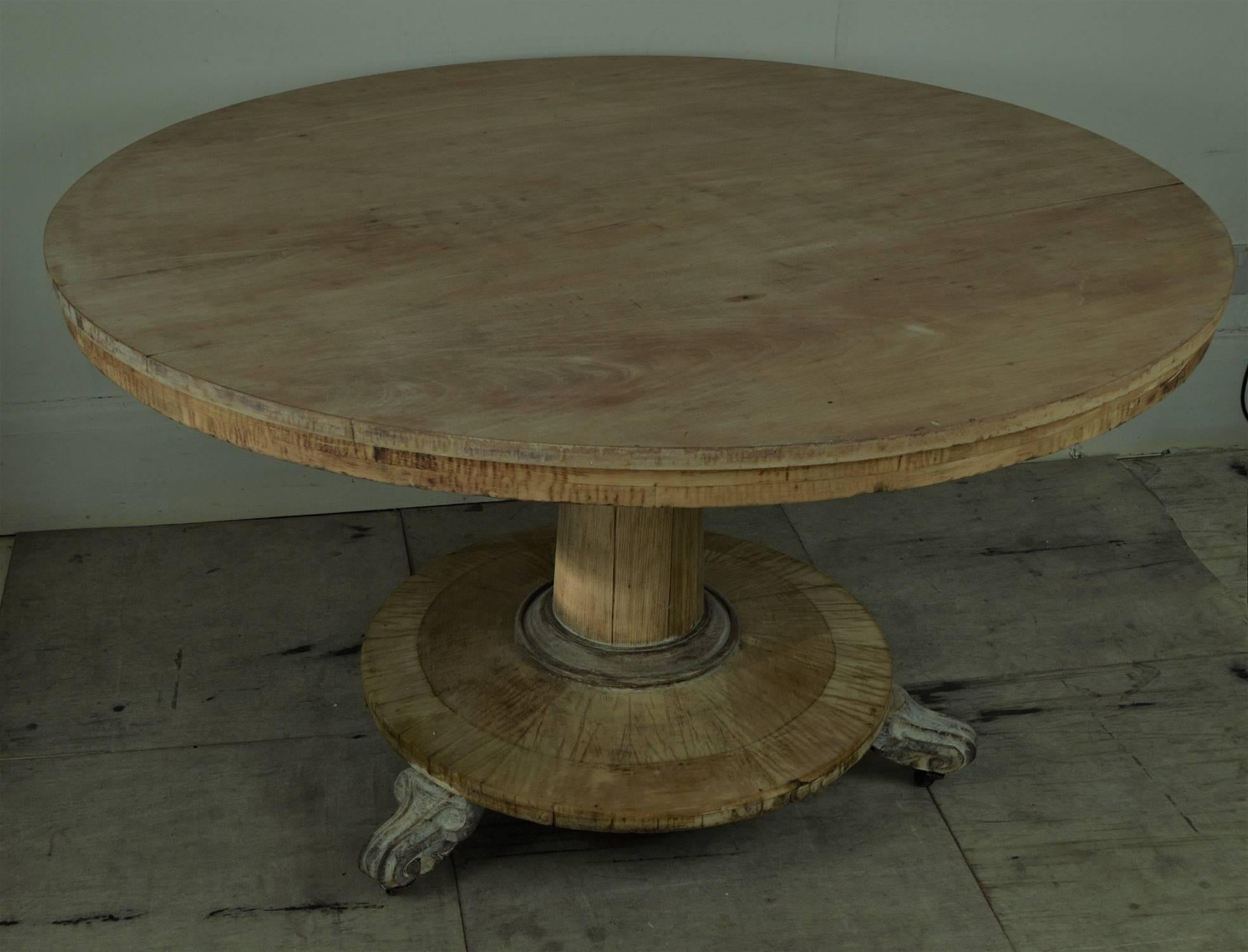 Wonderfully understated round dining or centre table made from four different types of wood.

Great simple lines.

The base and apron are pine. The carved feet are rosewood. The cylindrical pedestal support is ash and the top is bleached