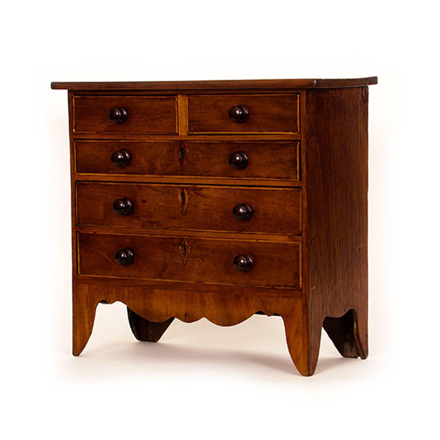 This petite chest of drawers cuts a fine and stable figure. It is country made and retains its original turned knobs.