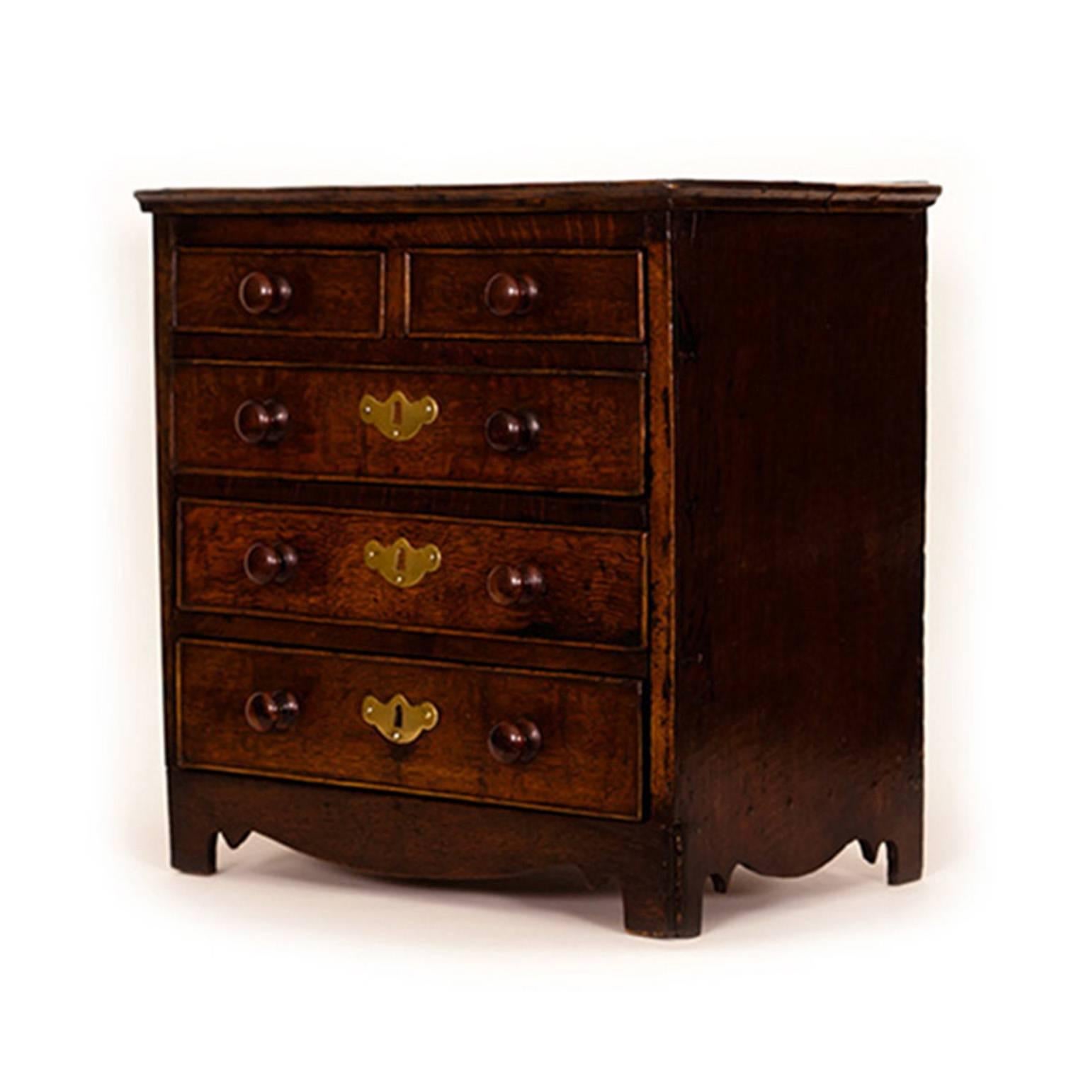 A sample-sized chest with a touch of country class. It is crafted wholly of oak and retains its original surface, color and turned knobs.