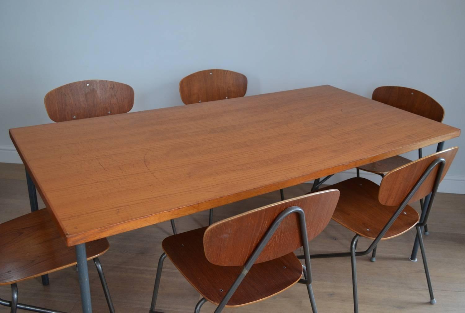 A 1970s vintage Industrial teak dining table and a set of six stacking chairs by Remploy.

Featuring beautifully shaped moulded ply and rich teak veneer seats and backrests, with tubular steel V frames. The seats have a lovely form and are