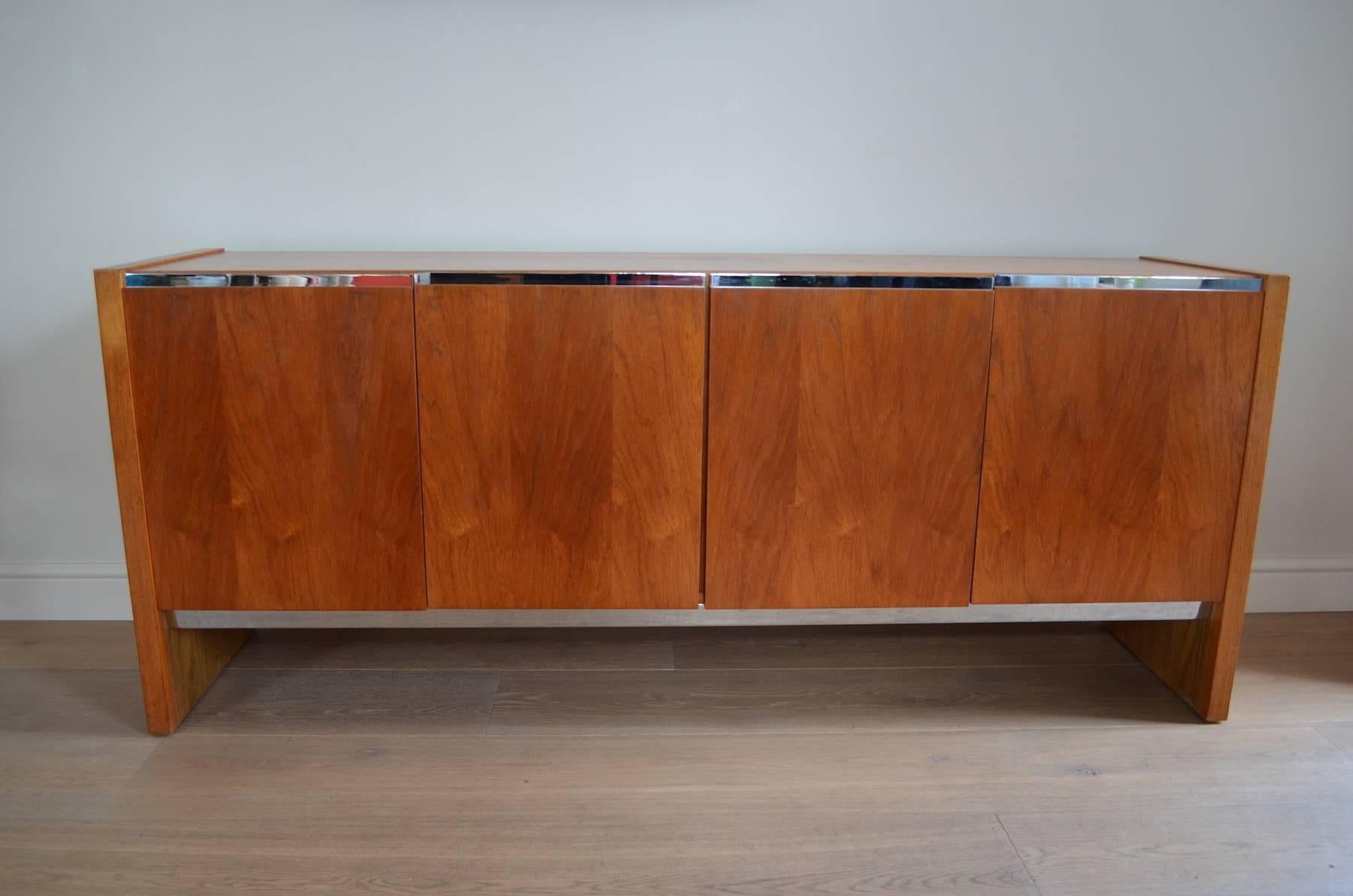 A rare and high quality 1970s Merrow Associates sideboard attributed to the well known design by Richard Young, England. 

Teak wood with chrome-plated steel trim. Good internal storage with drawers and glass shelving.
 