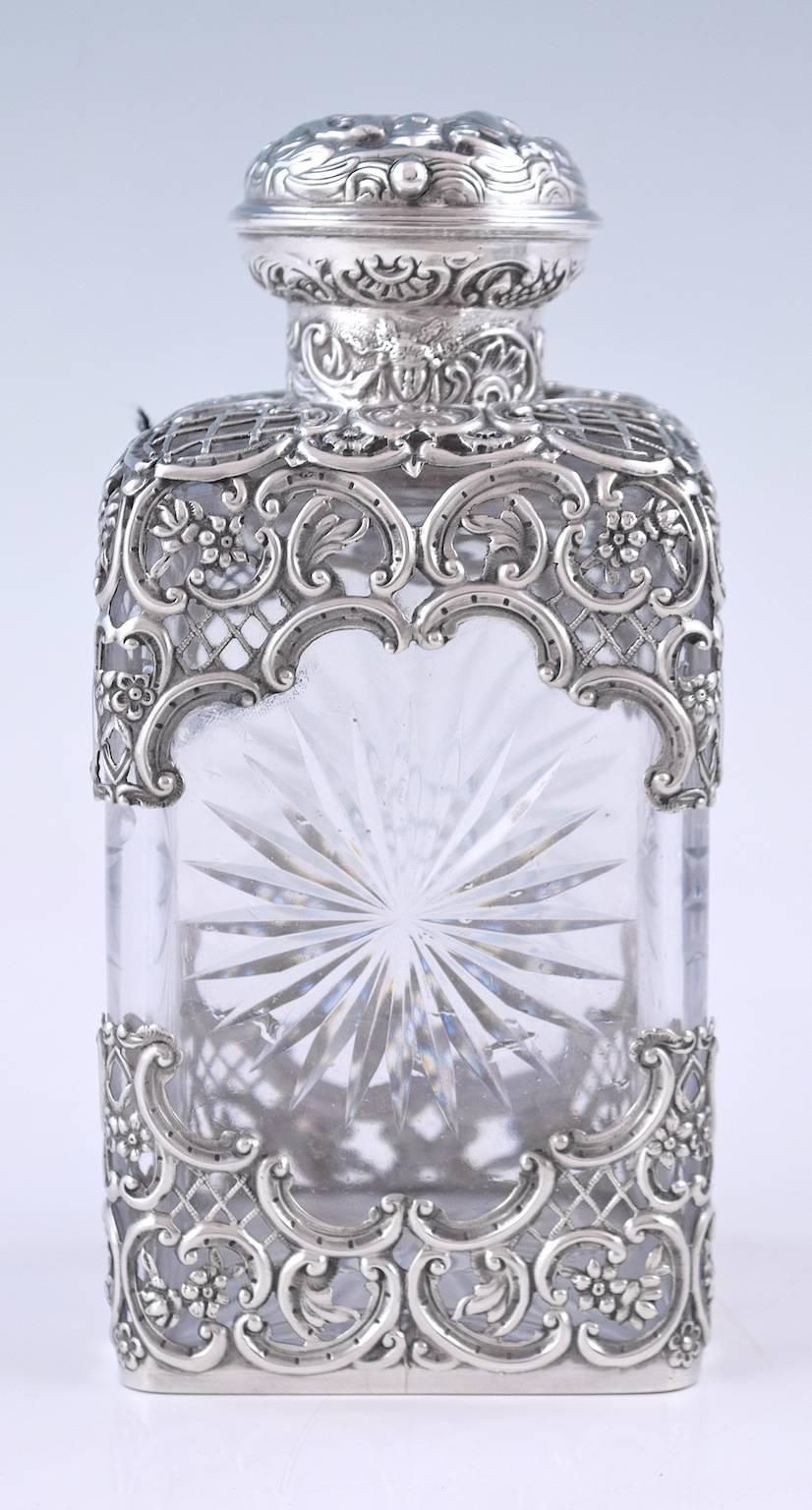 Openwork silver-mounts on glass, characteristic of the maker.
All sterling silver mounts hallmarked for William Comyns, London 1902, 1903 & 1904.
Each bottle with glass stopper.

The largest, 20 cm high and 9 cm square at the base.
The middle