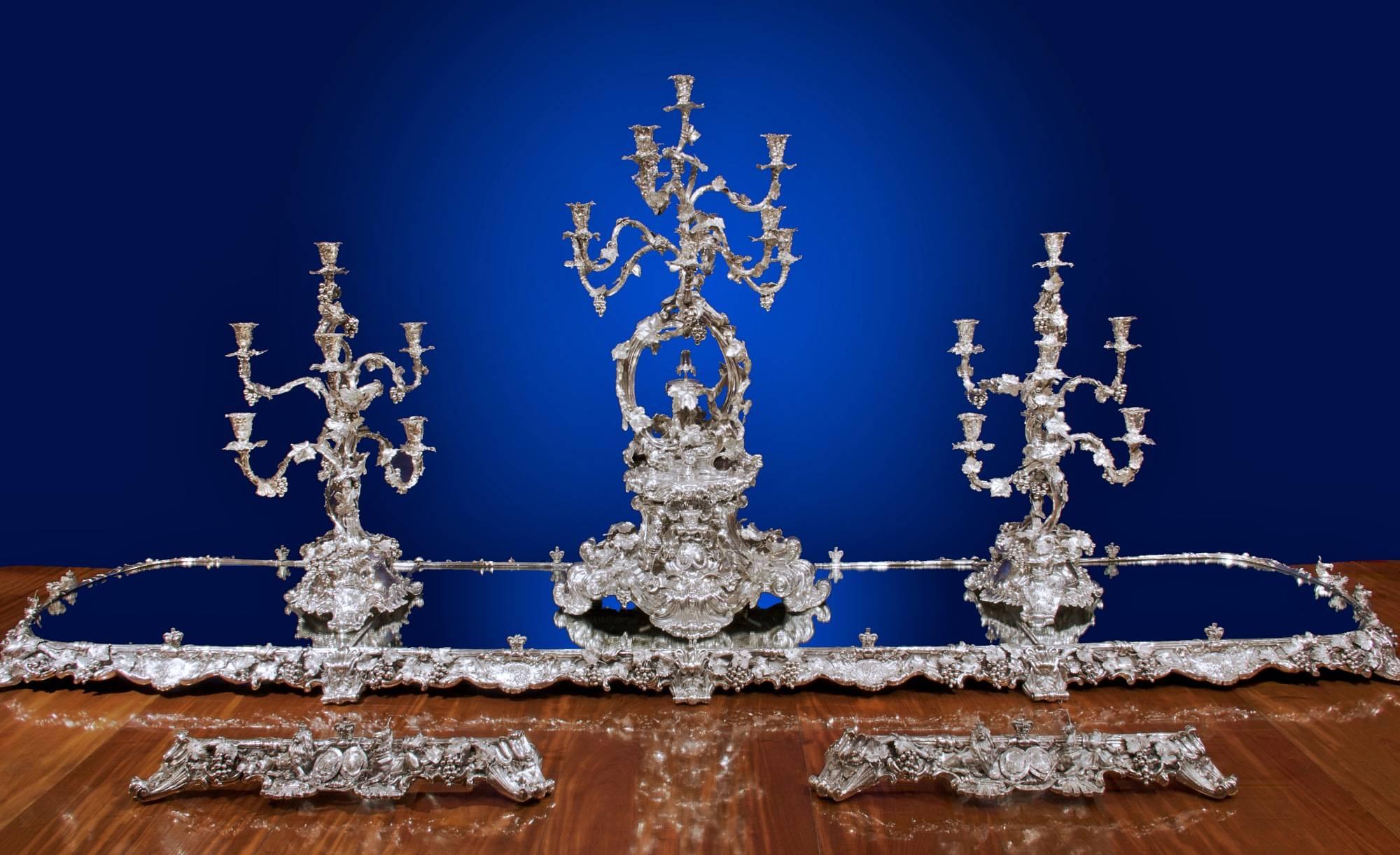 A magnificent Victorian silver table garniture by Robert Garrard.

London, with marks for R and S Garrard and R and S Garrard and Co, 1839 and 1852
Comprising a large silver mounted Mirror Plateau, in four sections, two with oblong ends, two