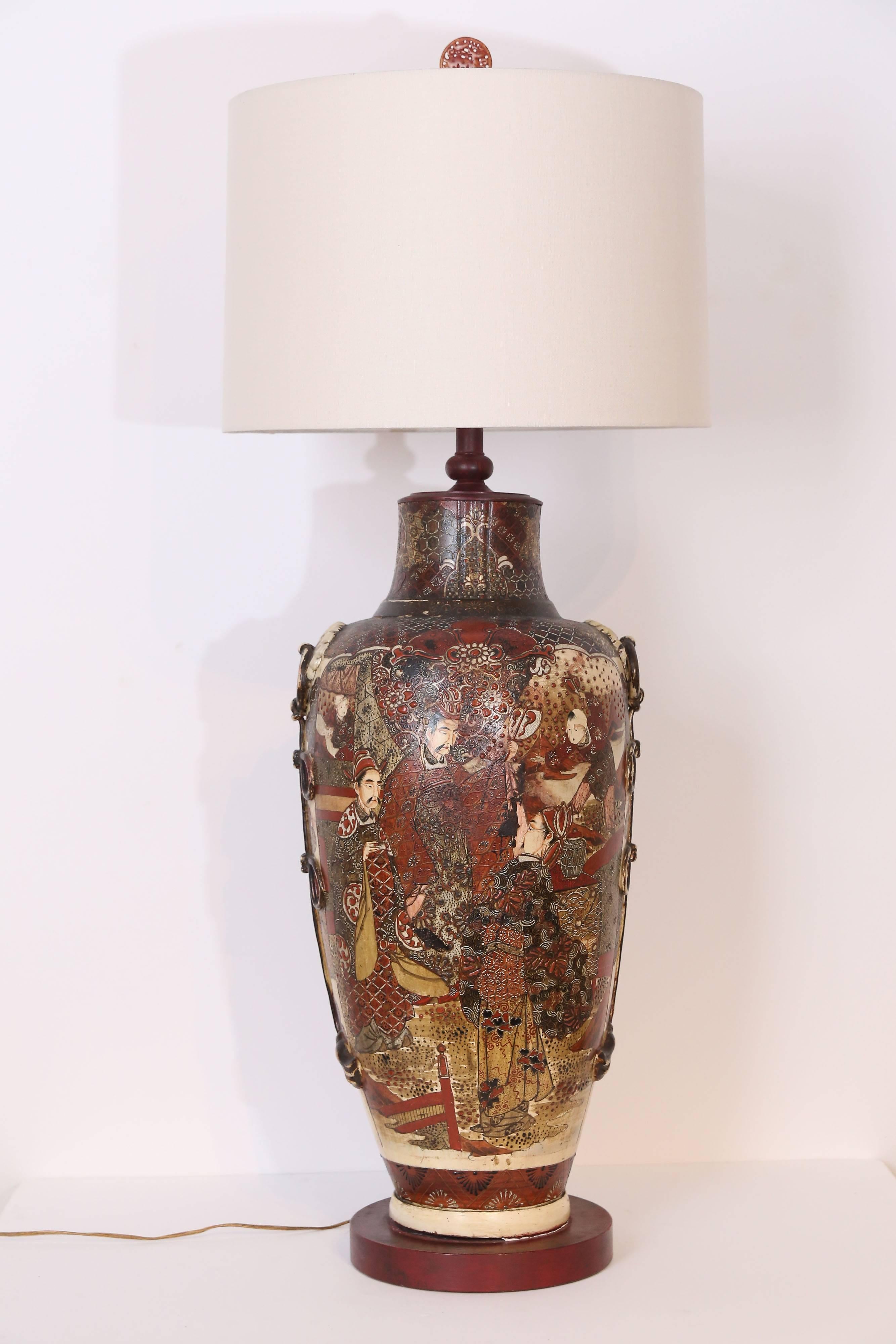 Beautiful glazed porcelain lamp in rusts, creams, whites and burgundies. Carved apricot jade finial of a running deer.