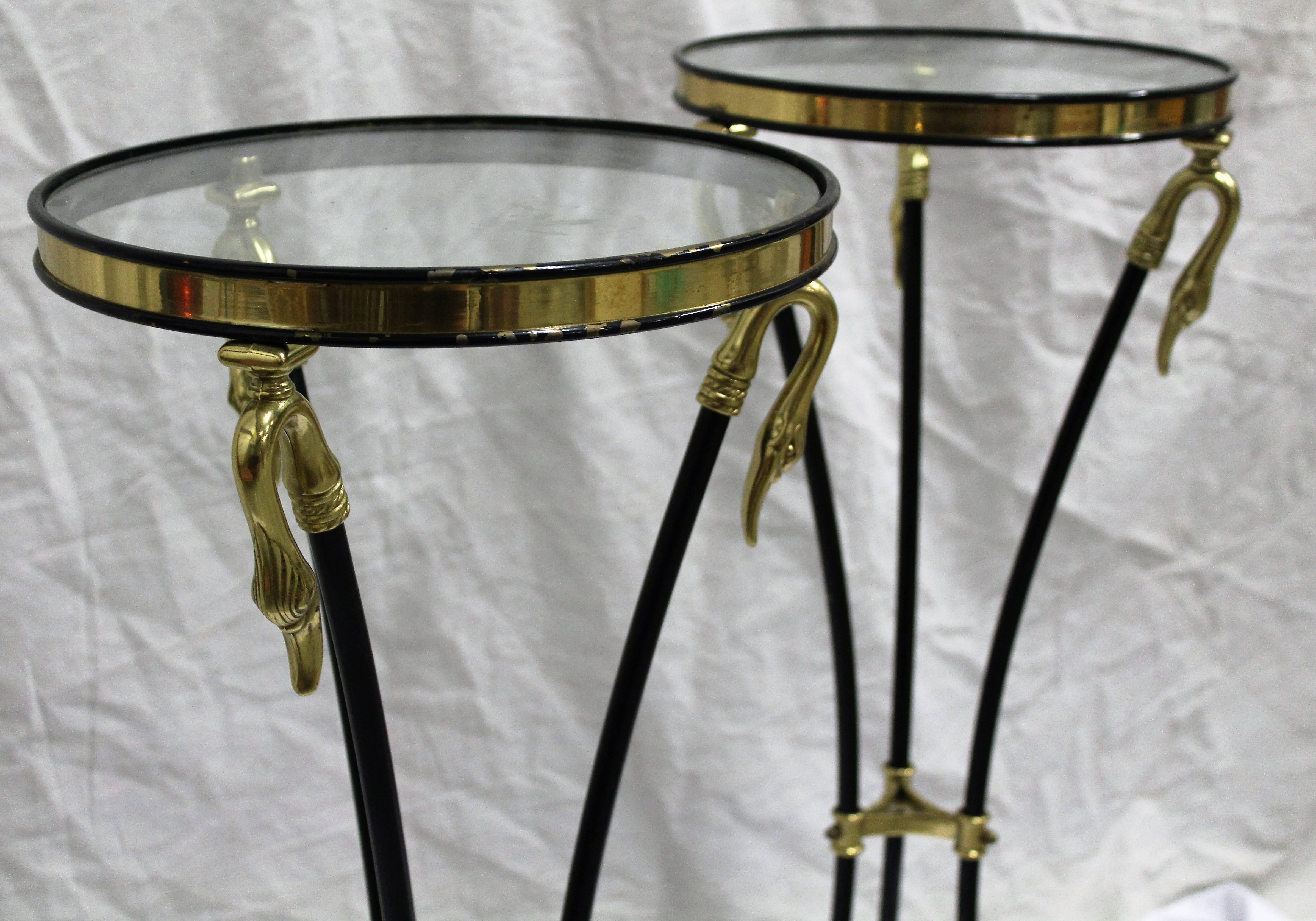 Charming pair of Empire styled pedestals. Graceful brass swan heads base the brass and glass top and curved ebonized legs provide brass claw feet to complete the simplicity of the design.