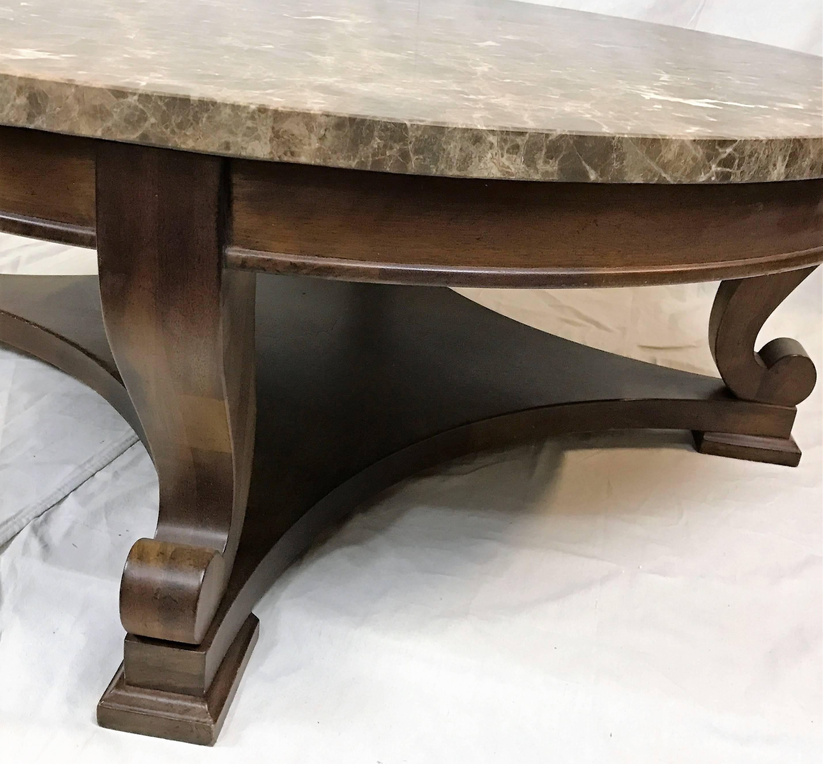 Beautiful 1960s dark mahogany and marble cocktail table attributed to Edward Wormley. It rises on scrolled legs joined by stretchers and a central shelf. Simple design enhanced by beautiful hand-carved joinery.