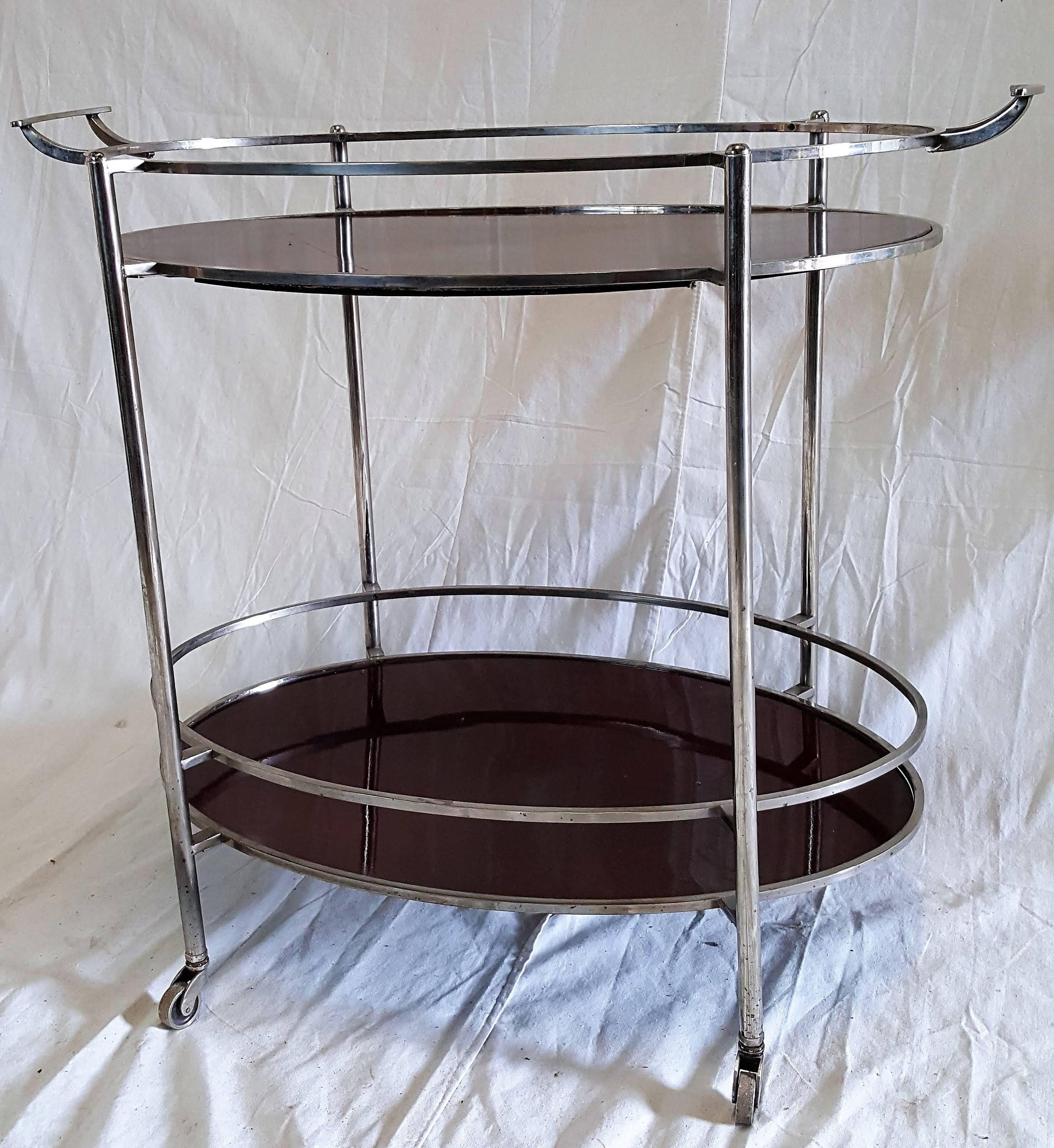 Mid-Century two-handled polished stainless steel and chrome dark cherry tea cart on casters with two shelves.