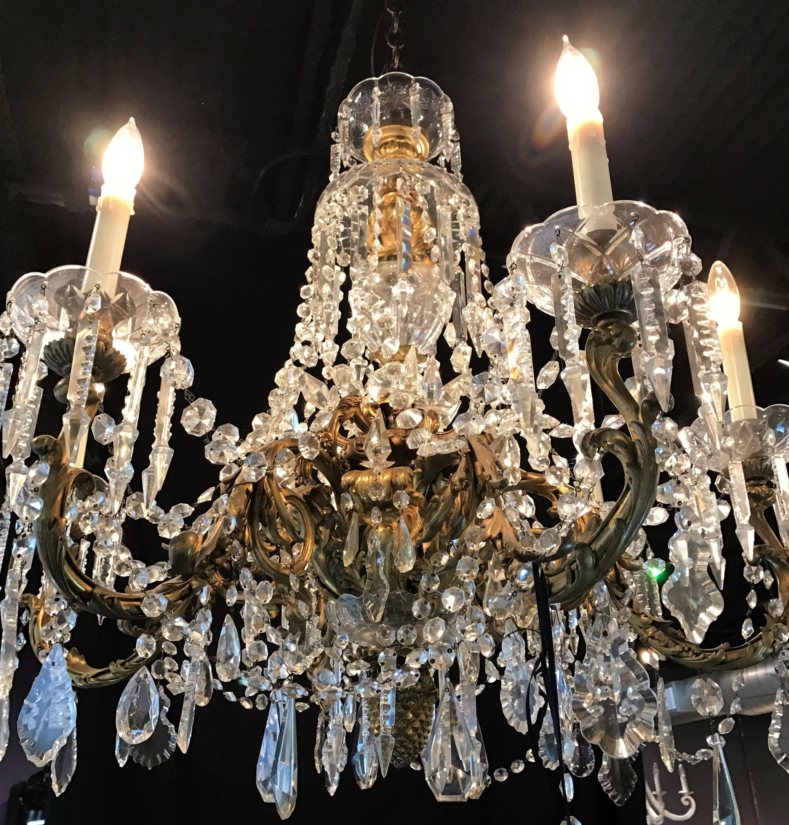Outstanding 20th century crystal and doré bronze six-light chandelier crafted by Baccarat. The gorgeous waterfall chandelier has a beautiful faceted crystal center and is adorned with hundreds of luminous prisms and crystal beads. An opulent