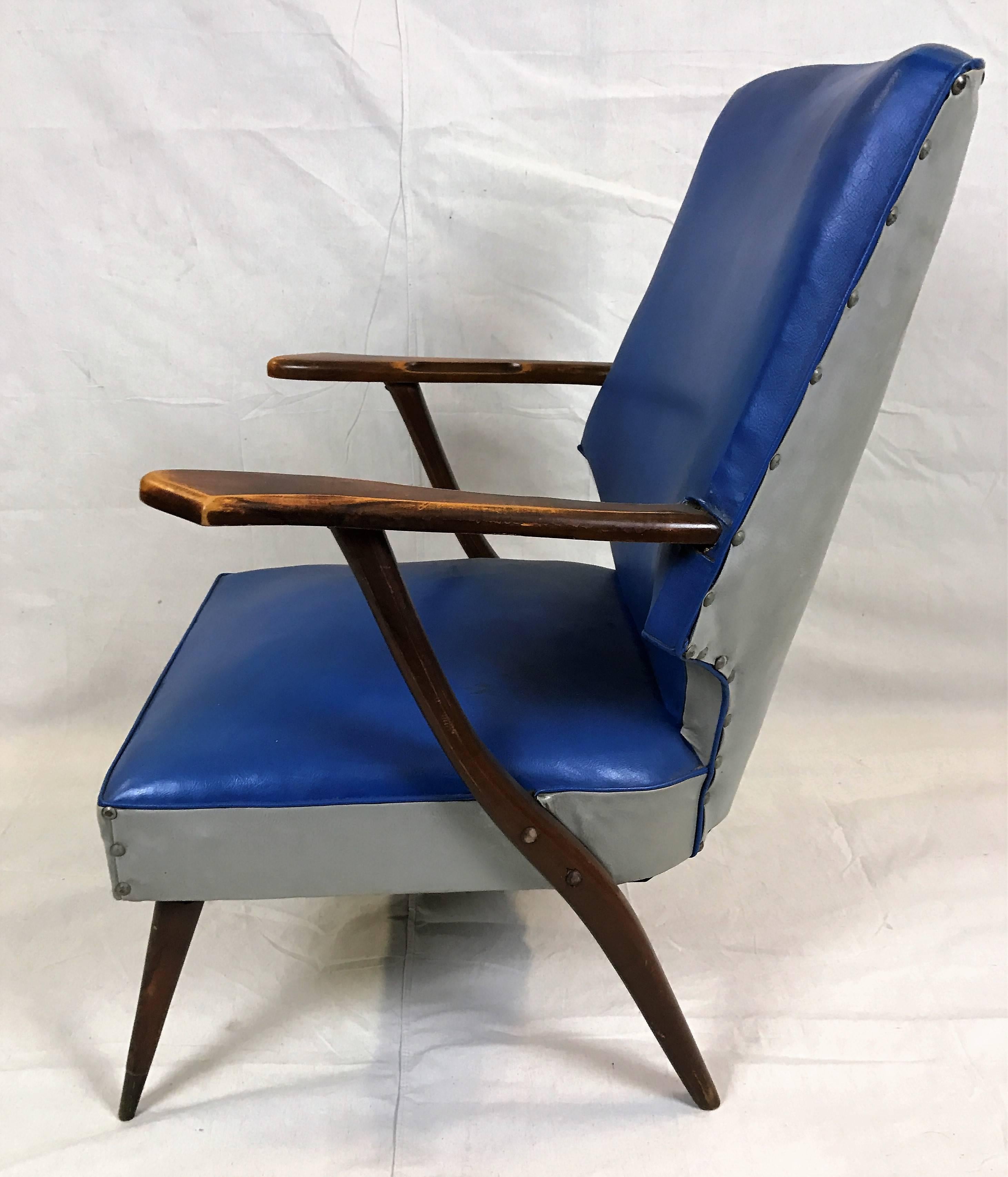 A simple design graces these two faux-leather lounge chairs created at the height of the 1950s. This pair of armchairs are attributed to Lucian Ercolani for Ercol. The form and lovely spoked elmwood arms complement the tapered and splayed legs.