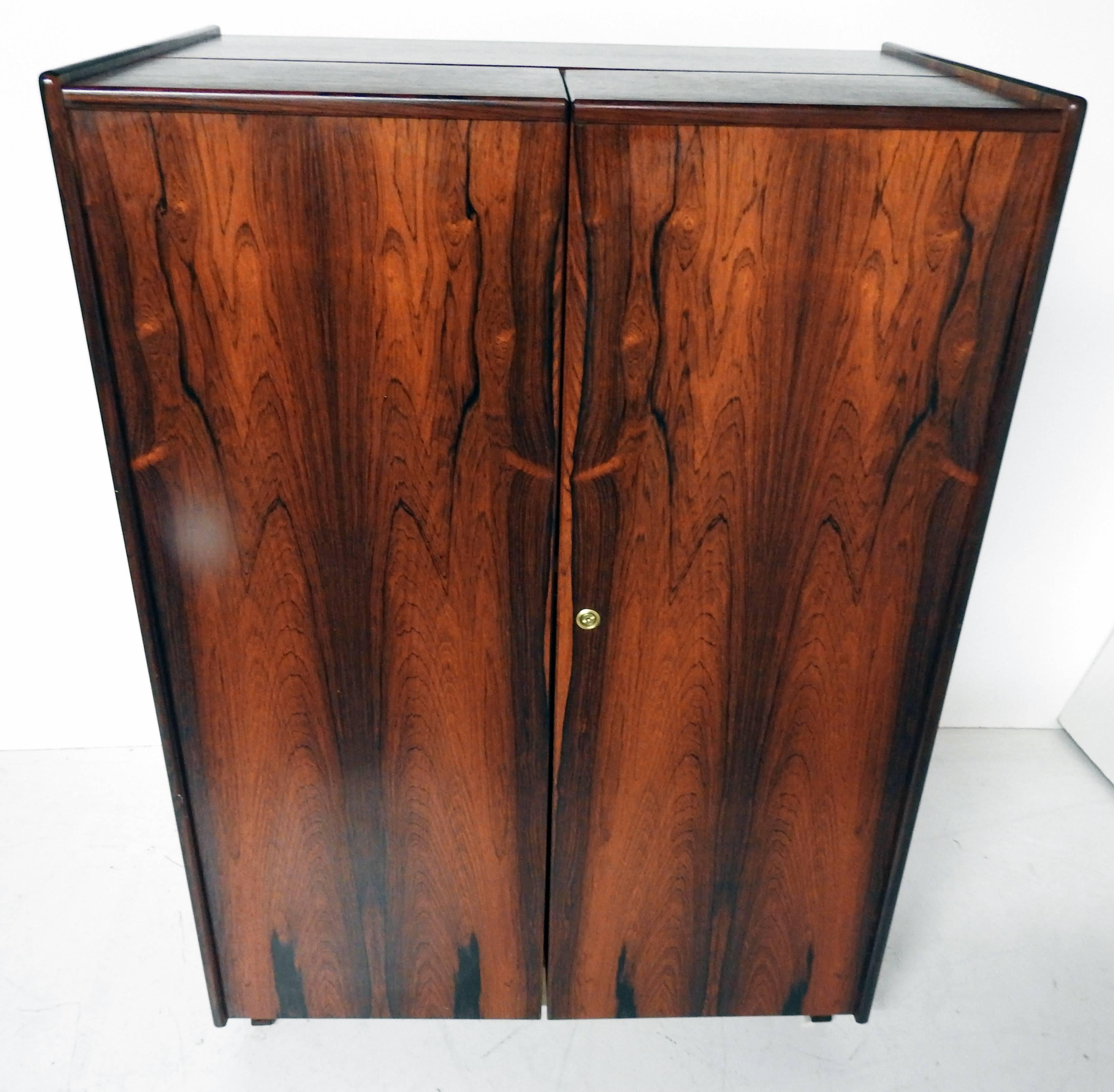 Cabinet form with two hinged doors that open to expose a full desk that slides out with a drawer and shelves.
