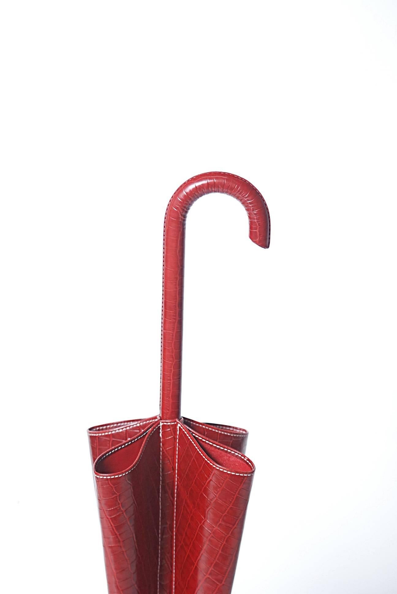 Red umbrella stand with reptile skin pattern in the leather. Marked on bottom 