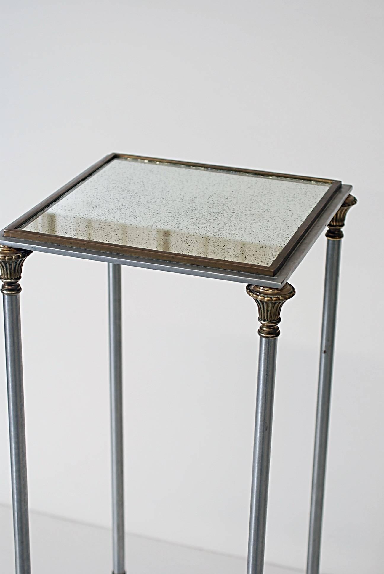 Aluminum pedestal with brass mounts and a distressed mirror top.