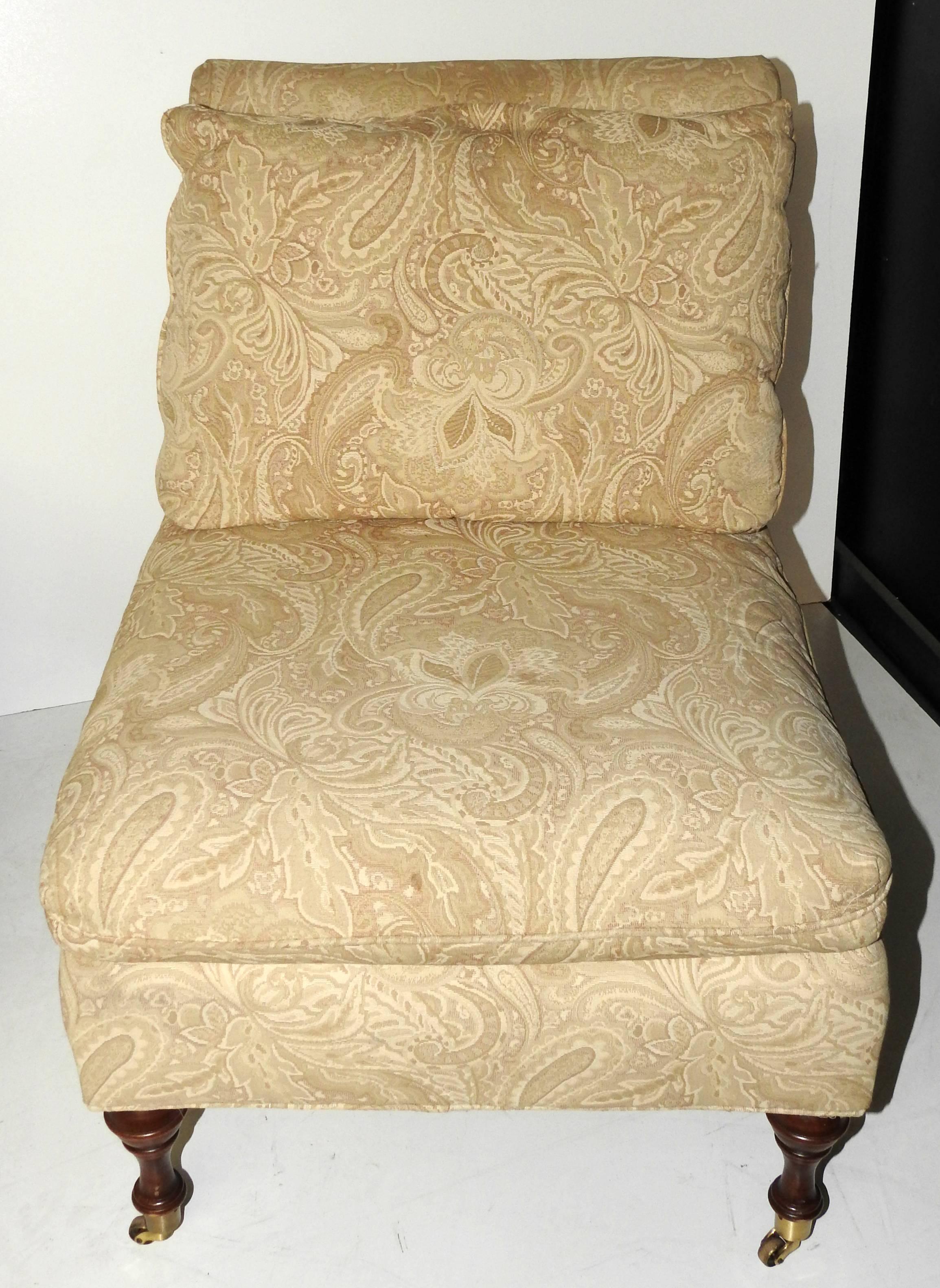 Pair of Regency style upholstered slipper chairs with removable cushions and turned front legs on brass cup casters.