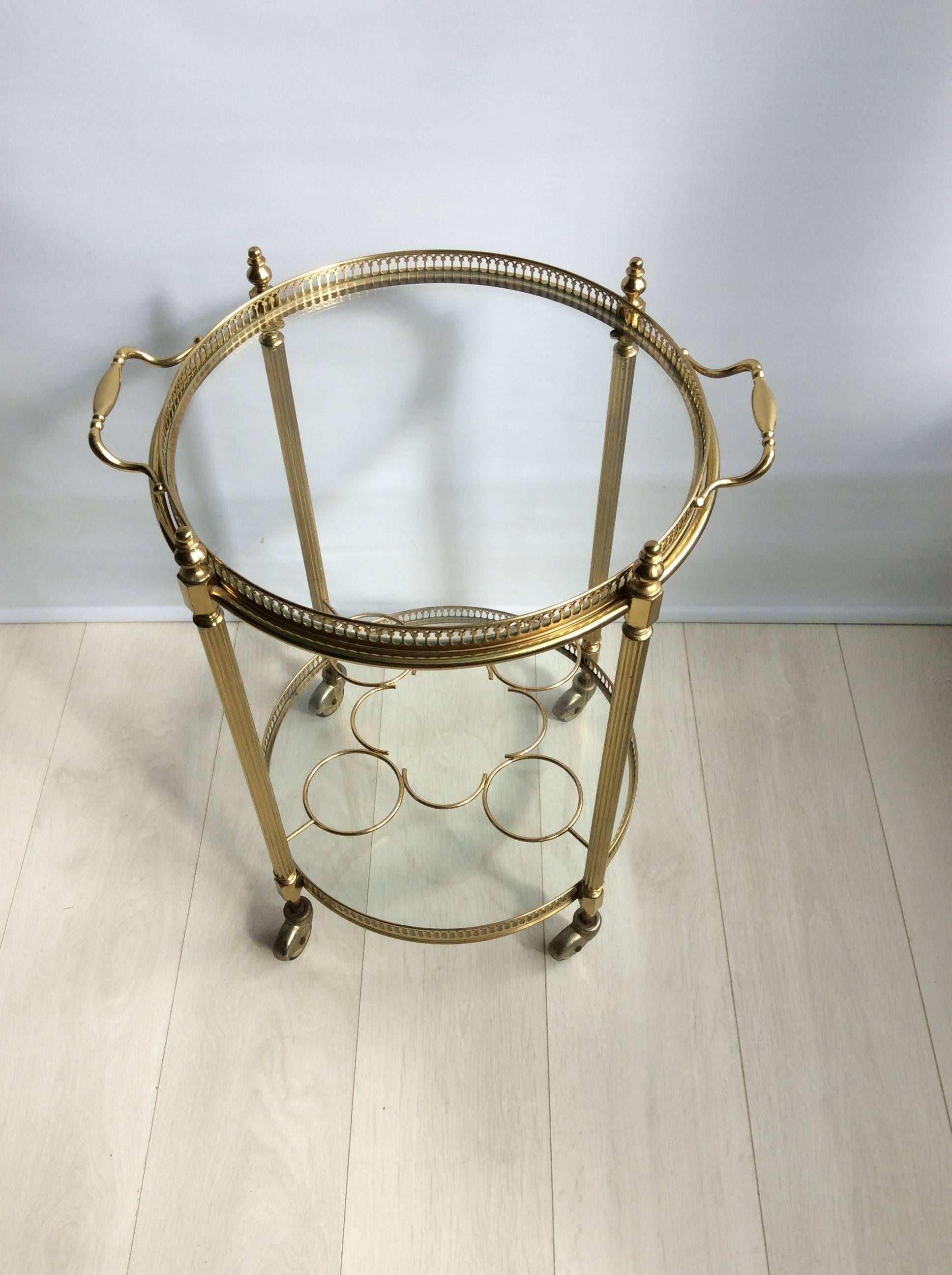 Perfectly formed circular French drinks trolley, circa 1950.

Lovely coloring to the lacquered brass frame with bottle holder to the lower tier (can be removed).

Top tray measures 40.5cm across, 49.5cm with handles and stands 59cm tall to