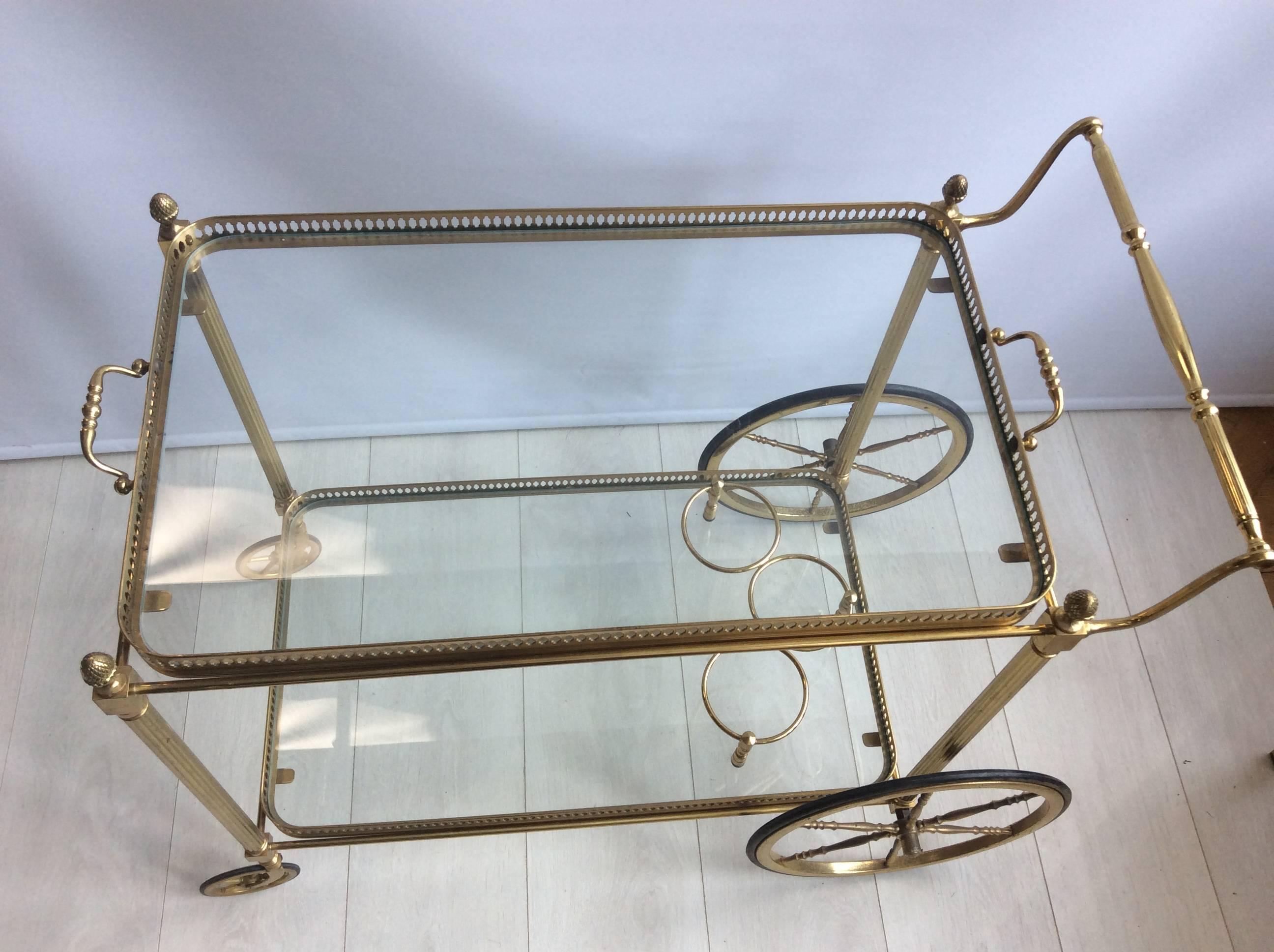 A Classic vintage drinks trolley from France, circa 1950.

Good quality piece with glass trays and decorative and finials.

Top tray measures 62.5cm wide (excl handles), 36.5cm deep and stands 62cm to glass.

Overall dimensions 76cm wide, 46cm