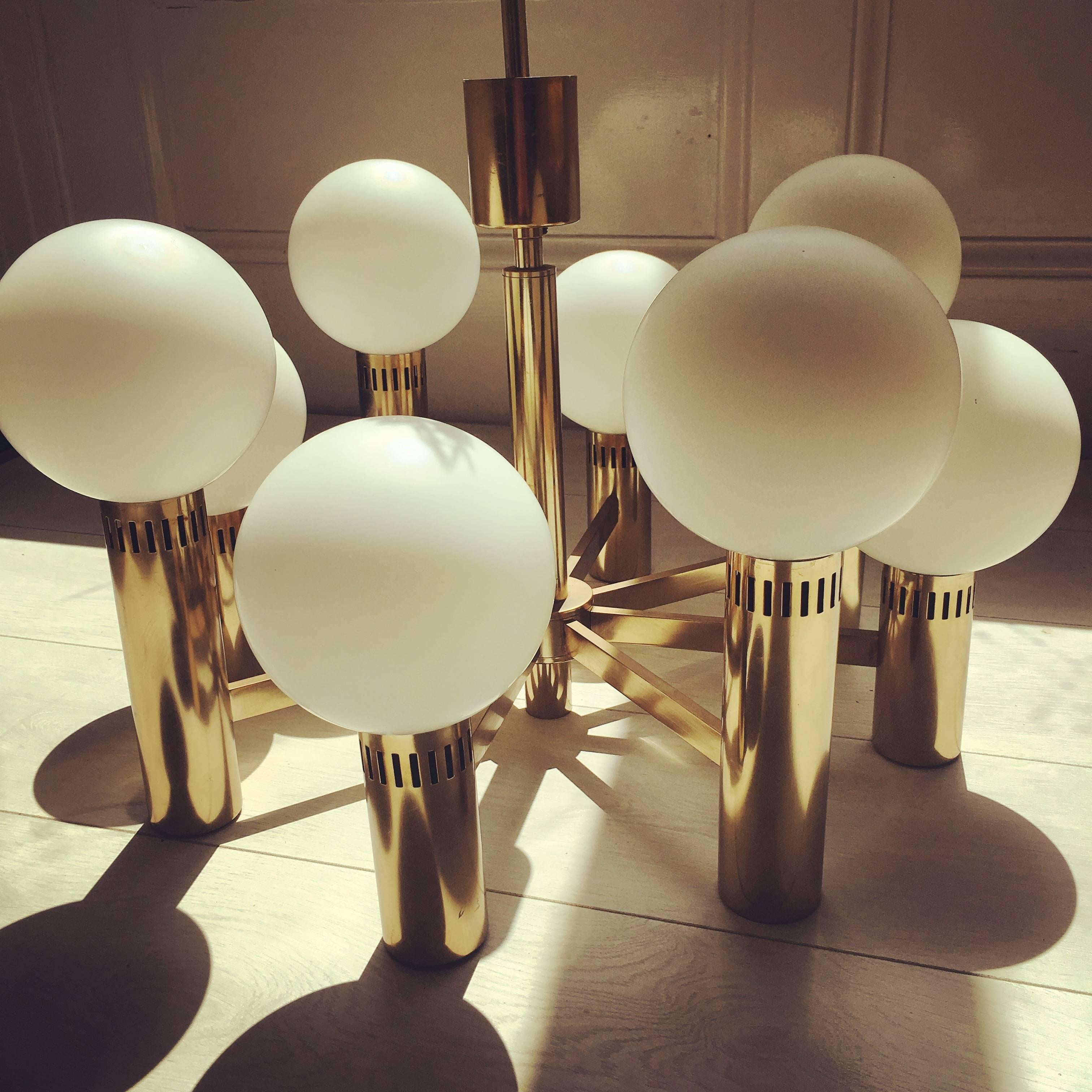 Elegant and sculptural eight-arm chandelier with frosted opaline glass globes.

Due the frosted glass these lights create a nice diffuse and soft light tone. 

The brass plate is in good vintage condition, one small loss at the base of one light