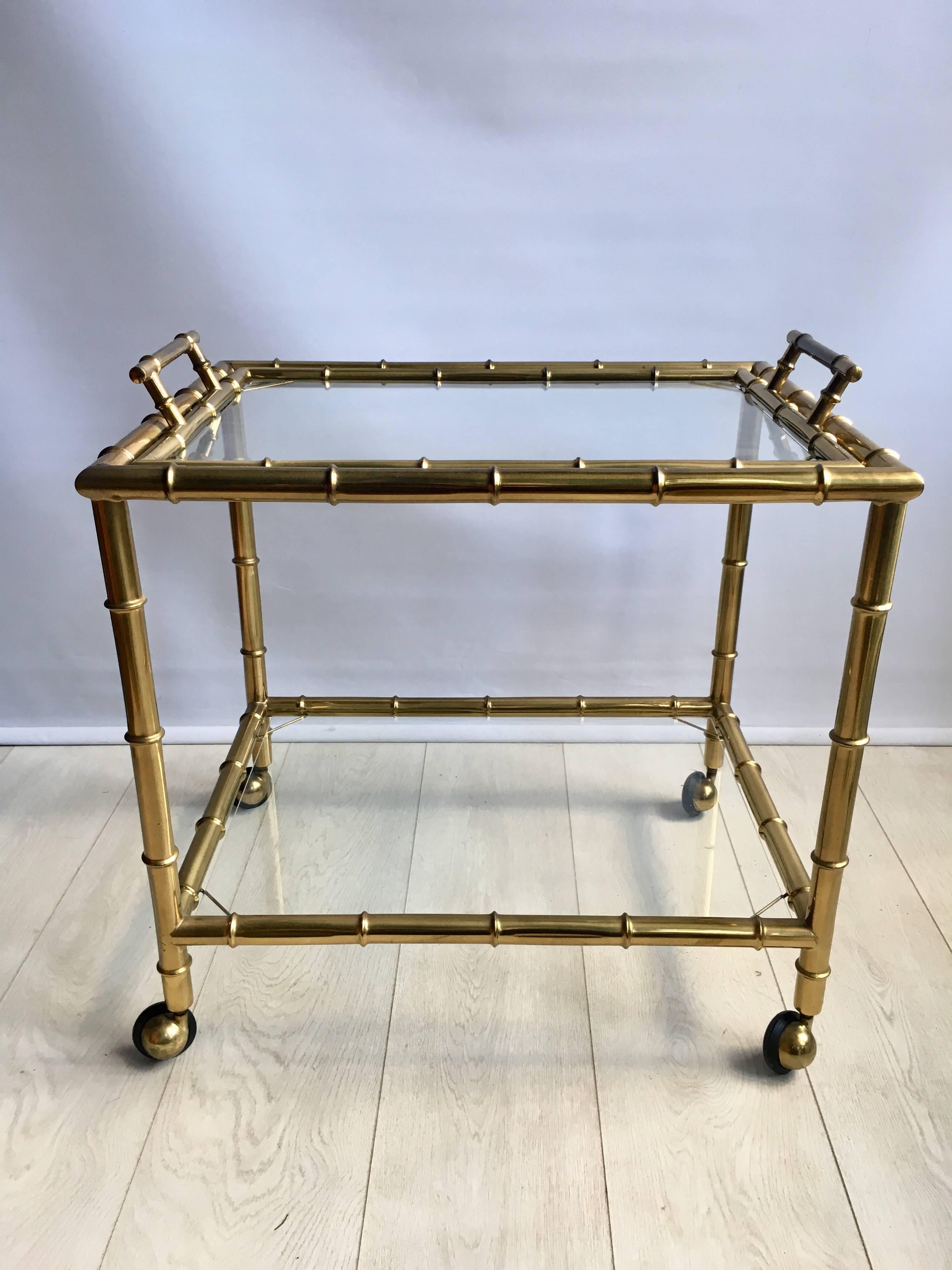 Chunky faux bamboo frame with lift off tray

Aged brass with lovely warm patina

Measures 60cm wide, 45cm deep and stands 61.5cm tall to handles (55cm to glass).