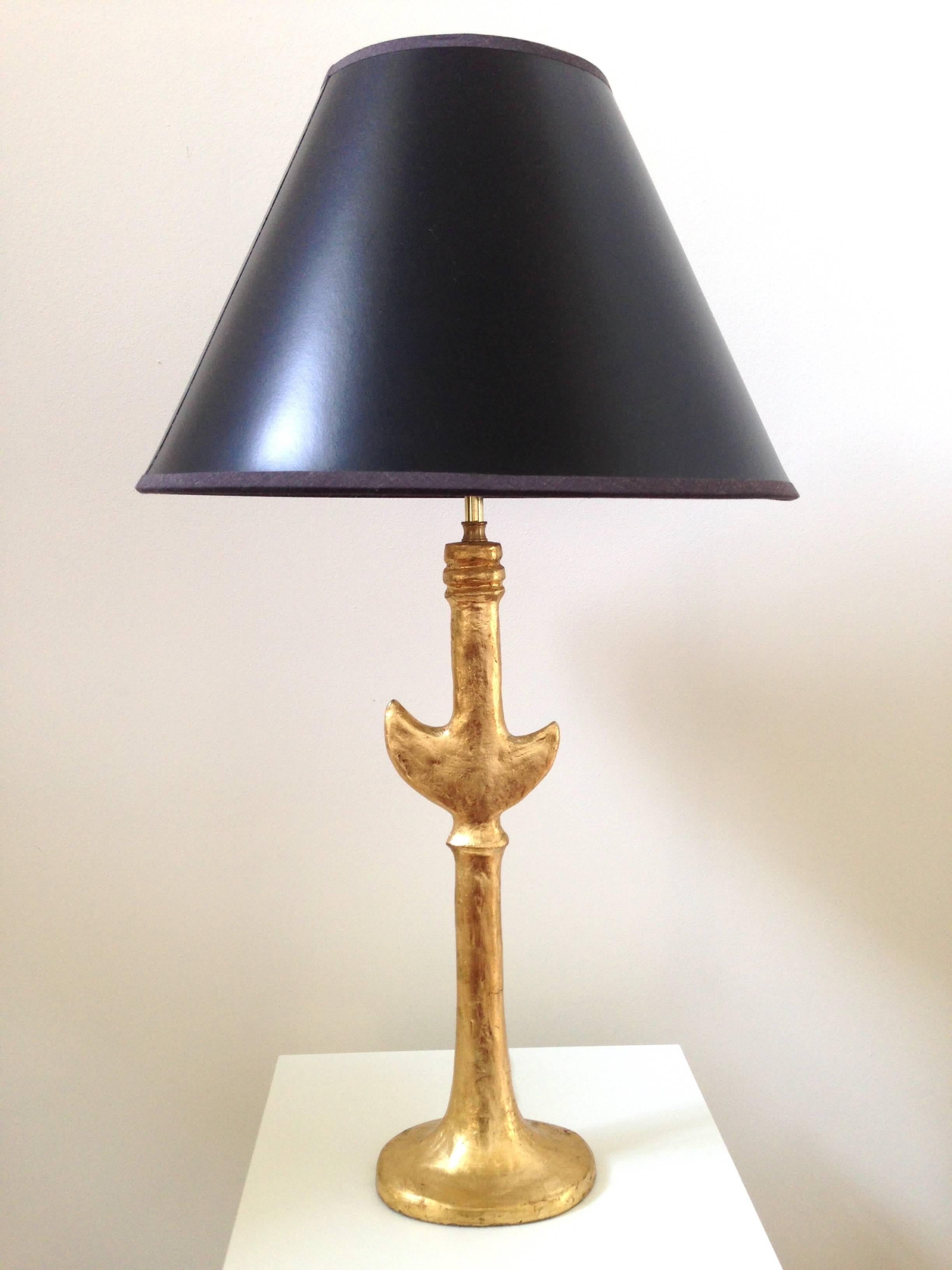 In the style of Giacometti's plaster lamps, this pair of lamps possibly by Sirmos have a gold leaf finish to them. A very attractive and stylistic pair, these lamps actually have a slight height difference although with shades you can't really tell.