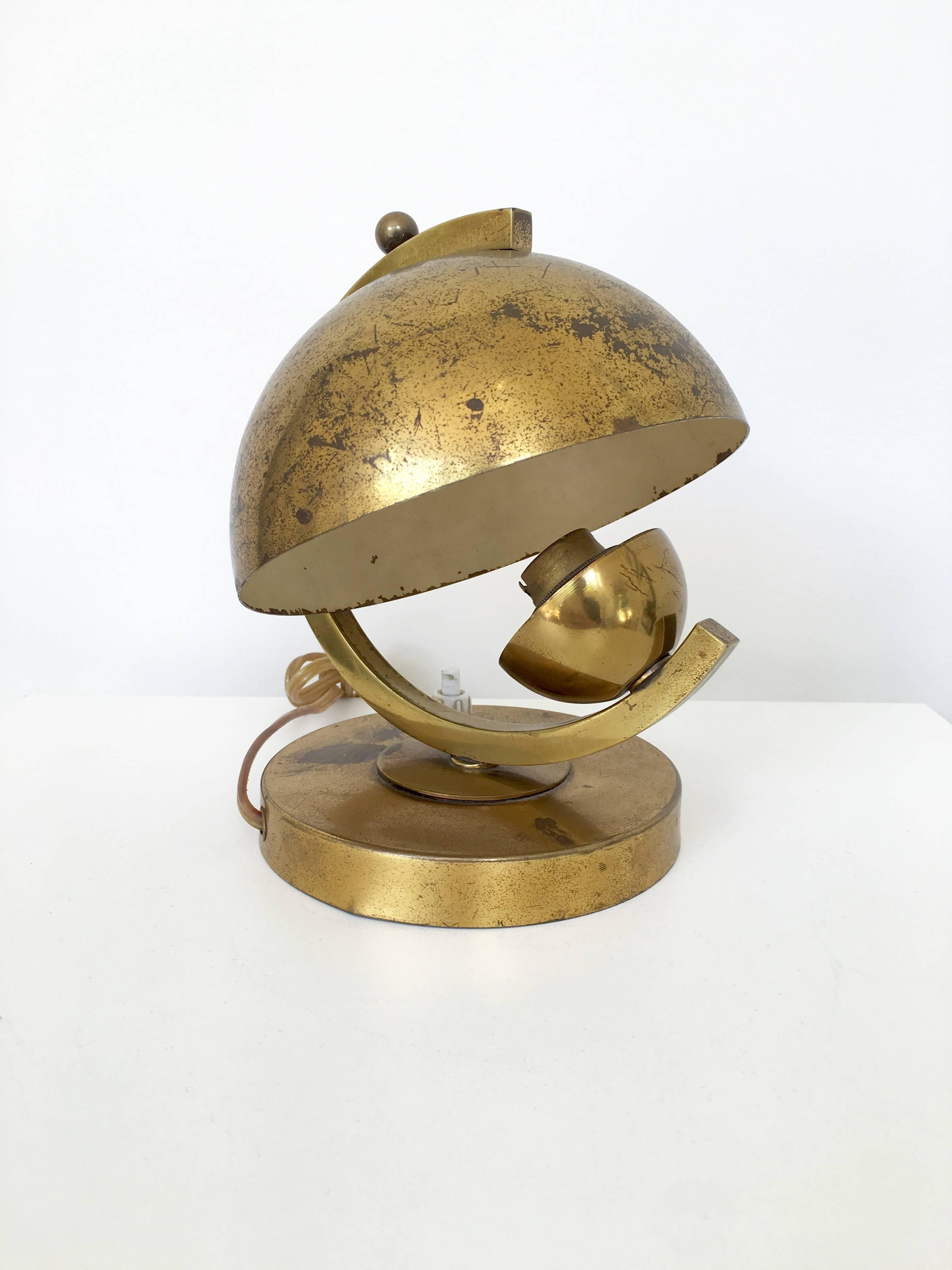 A petite and Classic Art Deco brass lamp in the style of Jacques Adnet and from the 1940s. The lamp is in it's original European wiring and has a wonderful aged patina.